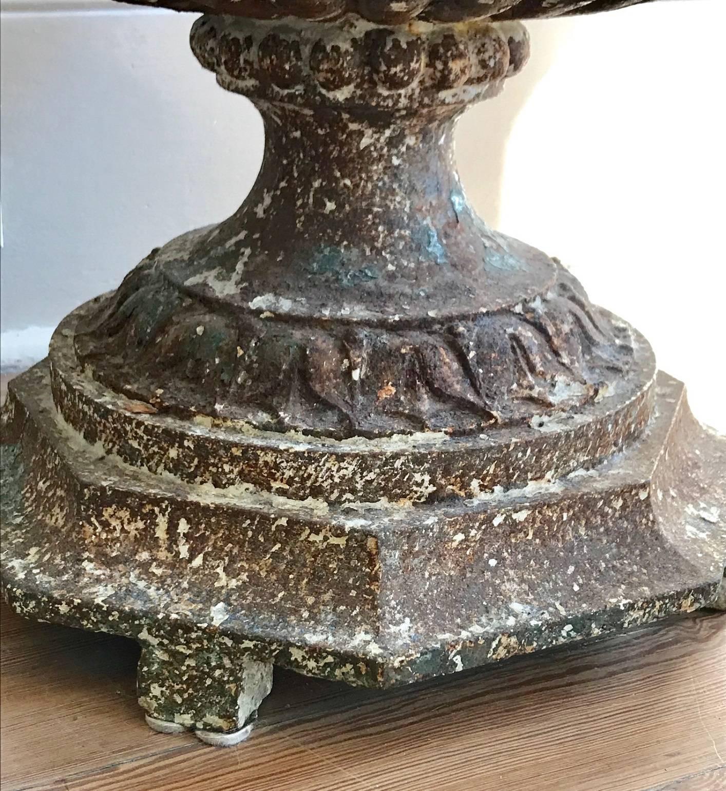 Large 19th century cast iron urn bearing traces of original white paint.
