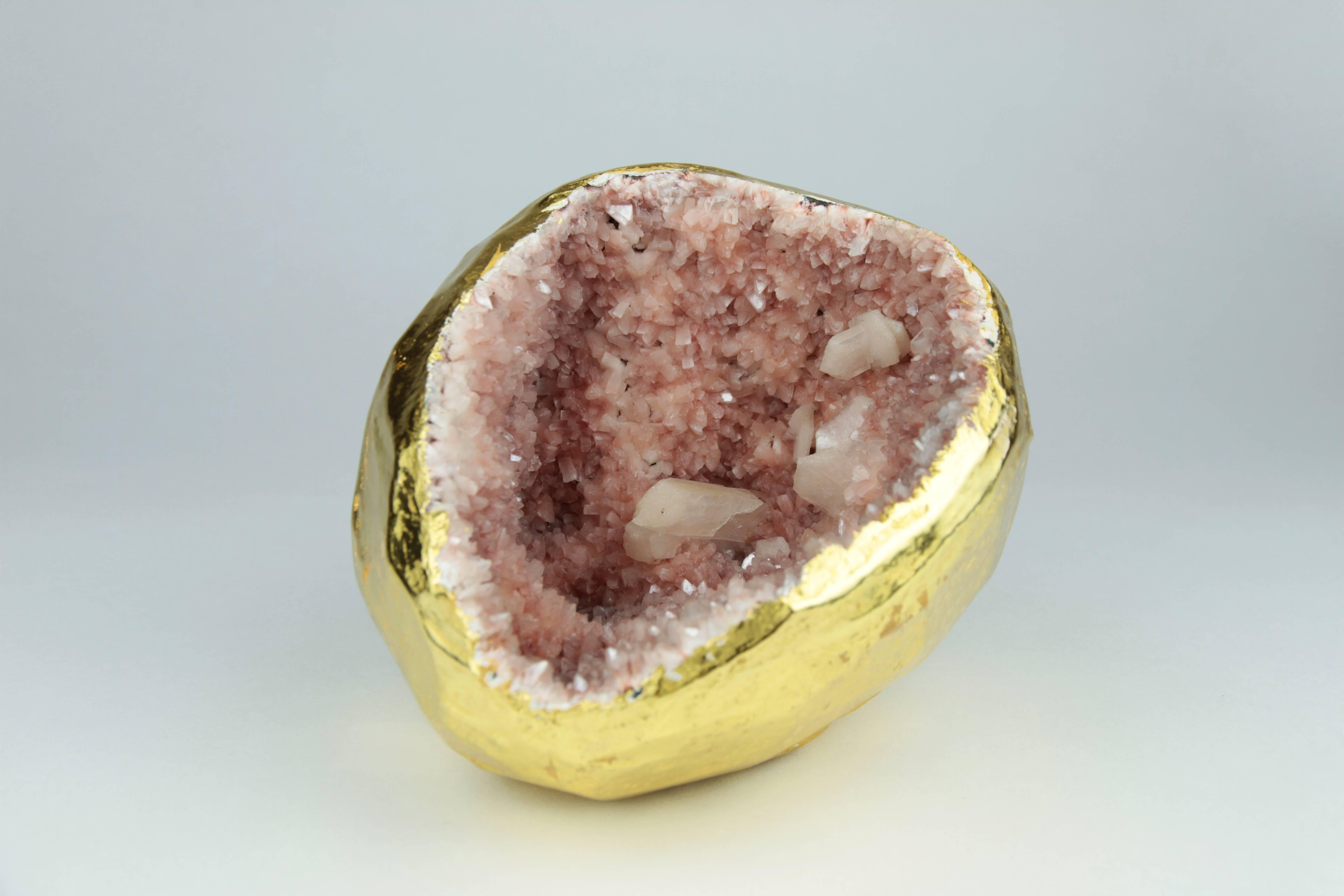 This is an exotic pink crystal geode found in India. It has been meticulously gilded in 22-karat gold. This natural sculpture will look amazing on a desk, coffee table, or anywhere it can be viewed from all sides. This geode is truly one-of-a-kind.
