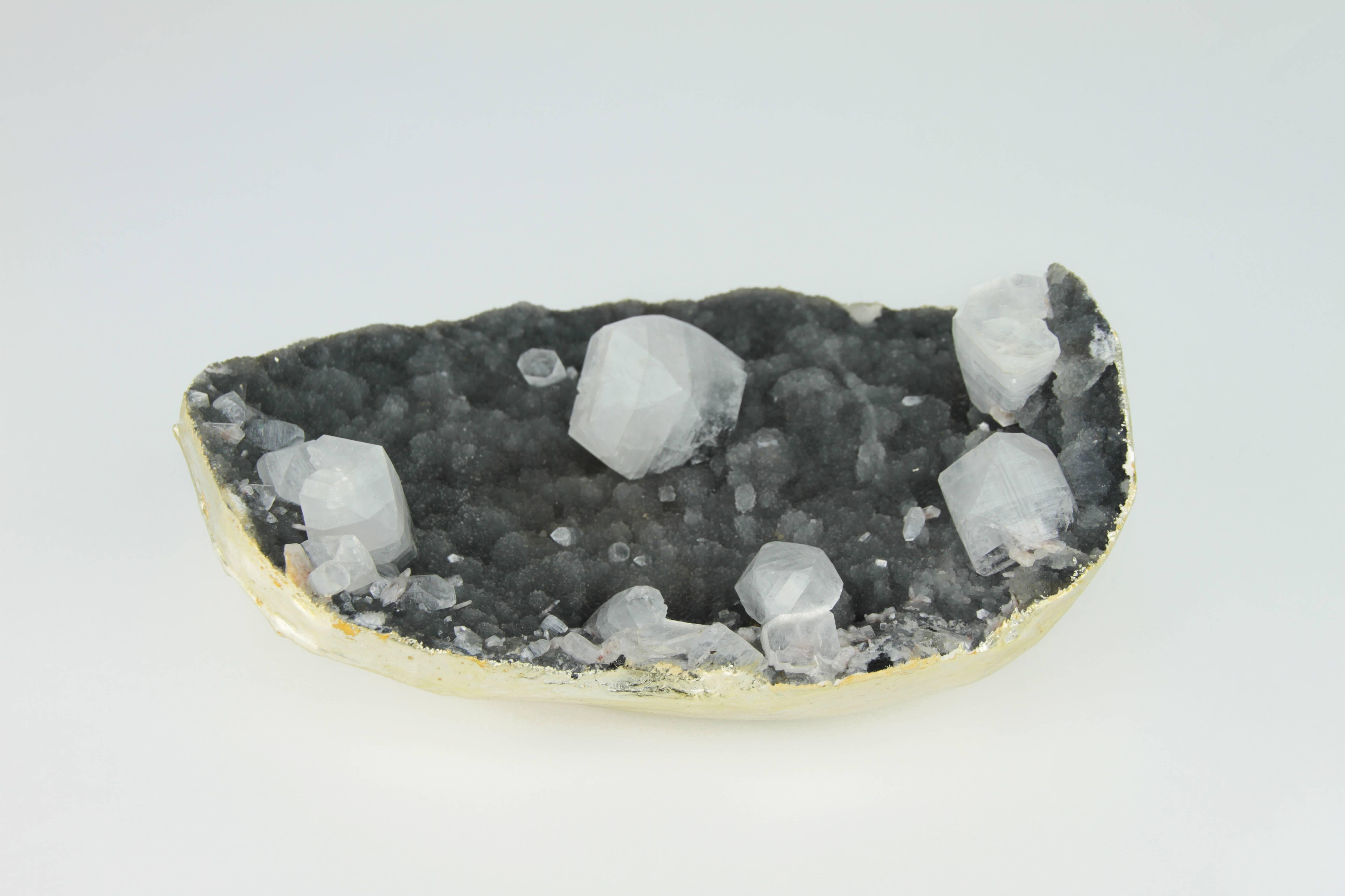 This is an cubist quarts crystal geode in black and clear found in India. It has been meticulously gilded in 22-karat gold. This natural geode will look amazing on a desk, coffee table, or anywhere it can be viewed from all sides. This geode is