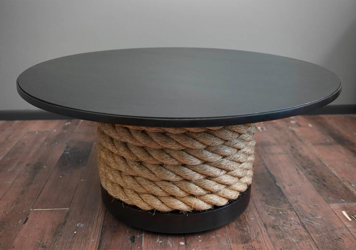 Der Steel and Rope Coffee Table ist ein robustes, gut verarbeitetes Möbelstück. Auf den versteckten Rollen gleitet er trotz seines hohen Gewichts leicht über den Boden. Das zwei Zoll große nautische Seil kreist und taucht in den Sockel ein und