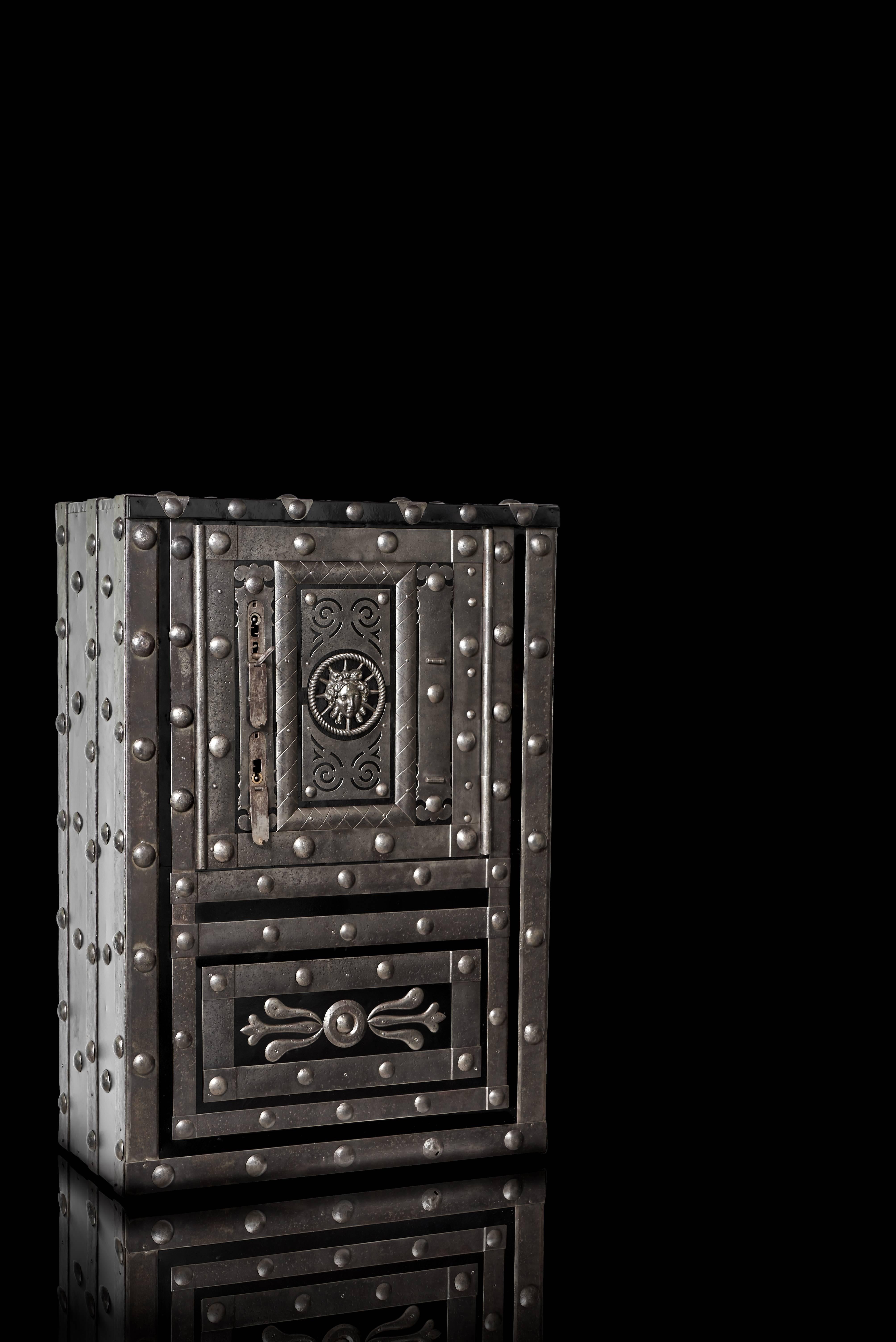 Beautifully decorated wrought iron 19th century Italian hobnail safe, dated circa 1790-1820. The safe features a black painted body to highlight its wrought iron hobnails and decors with a unique central human face.

The wide and deep interior of