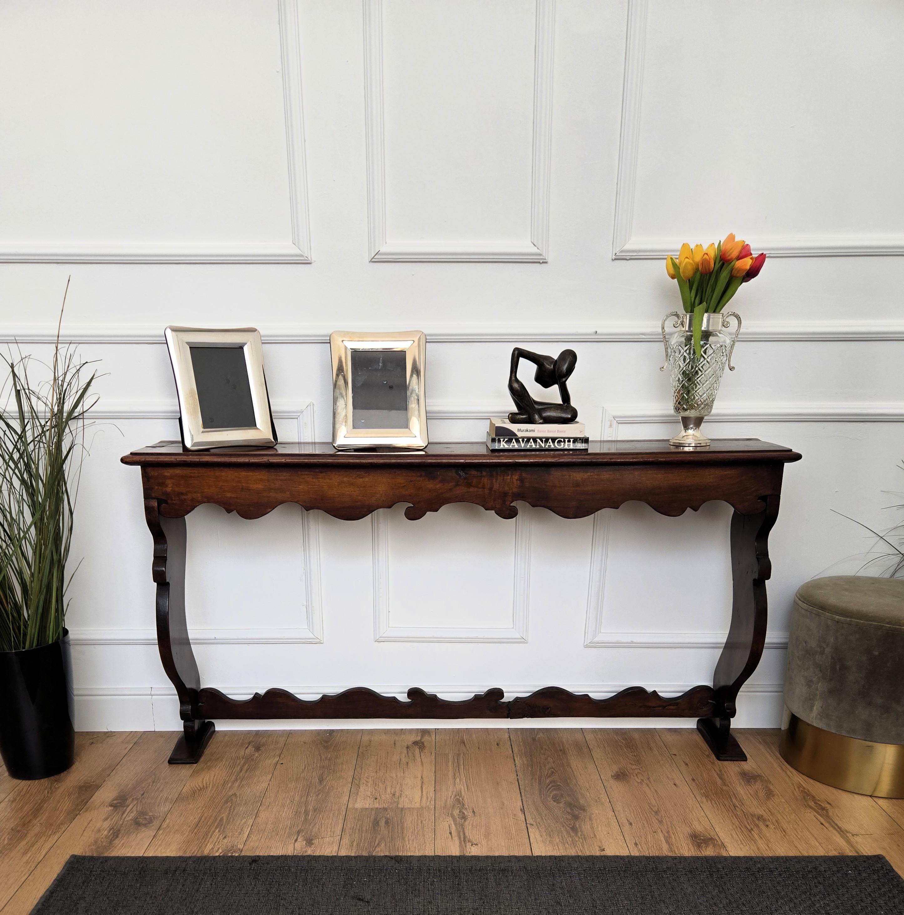 Beautiful Italian rustic country wooden console table, with trestle style legs in original aged natural color giving the rich and beautiful patina that makes it look wonderful in every interior highlighting the detailed carving design and decor.