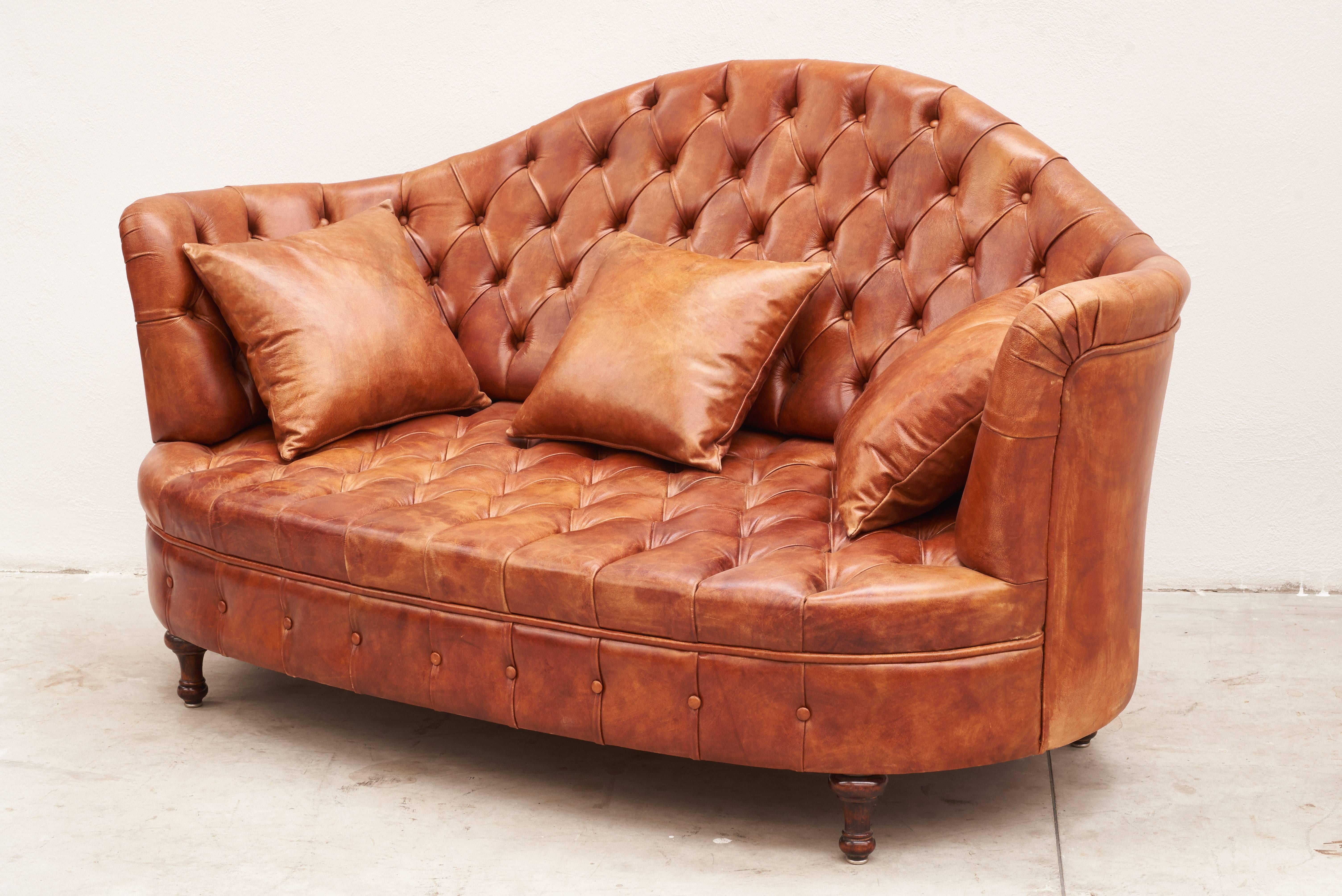 Leather Italian Chesterfield sofa with three leather pillows.