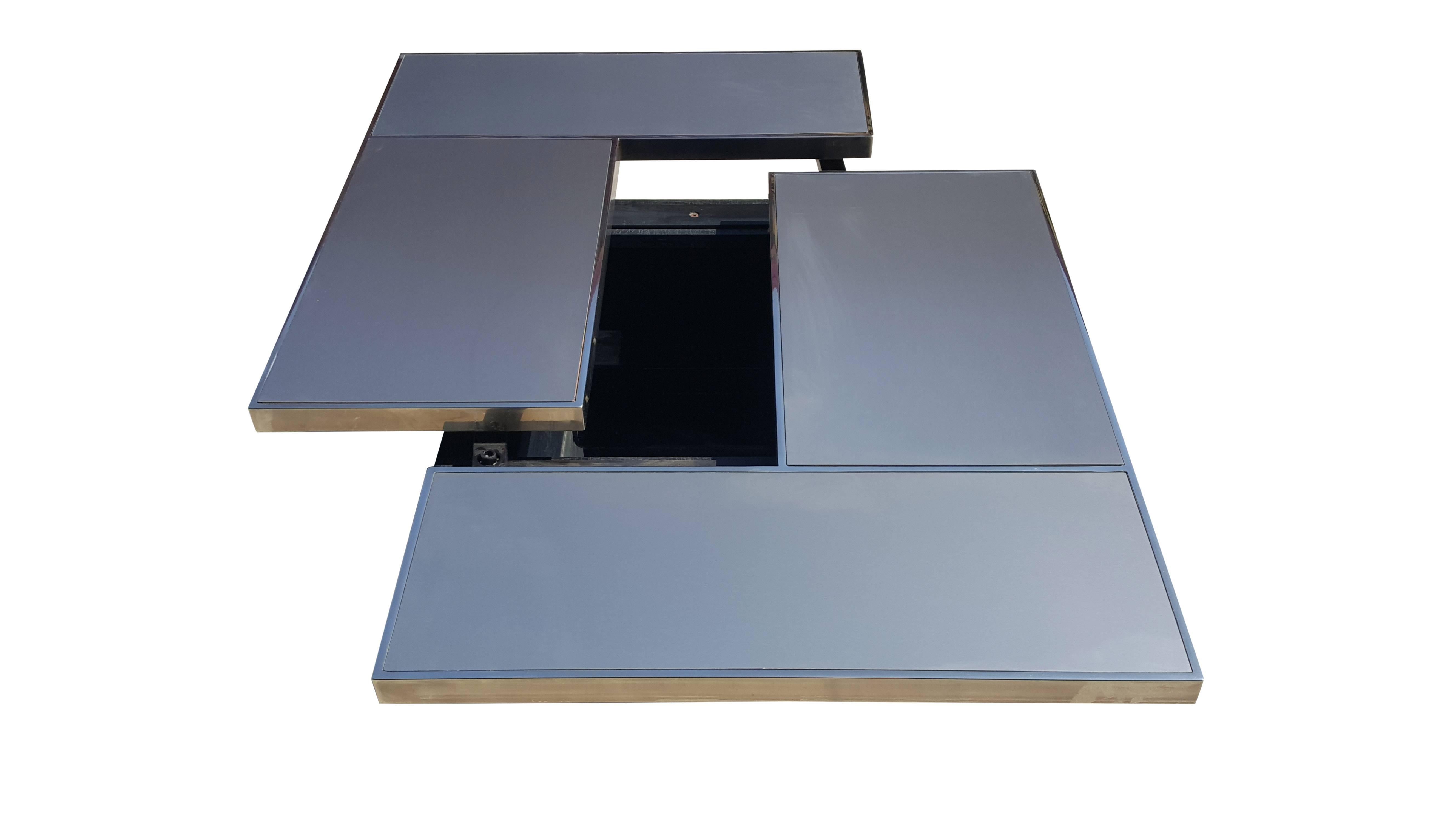 Special sliding table in stainless steel with hidden bar from Belgo Chrom. In the style of Willy Rizzo and Maison Jansen. The table has chrome steel edges and a black laminated base.