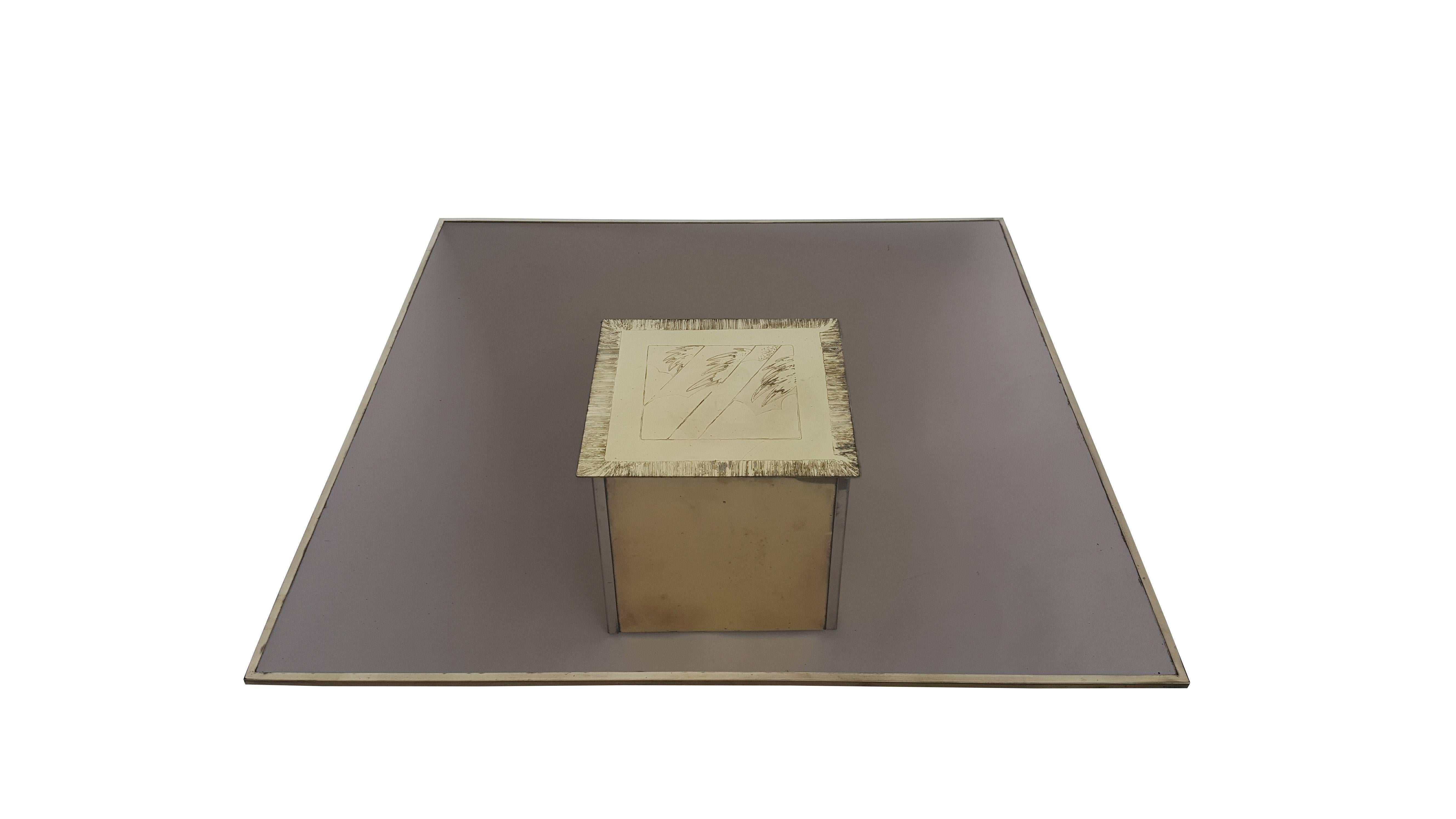 Impressive, amazing, massive coffee table! 

Smoked glass tabletop.
Surrounded by a brass frame.
Brass etched plate in the middle.

In the style off Maison Jansen.