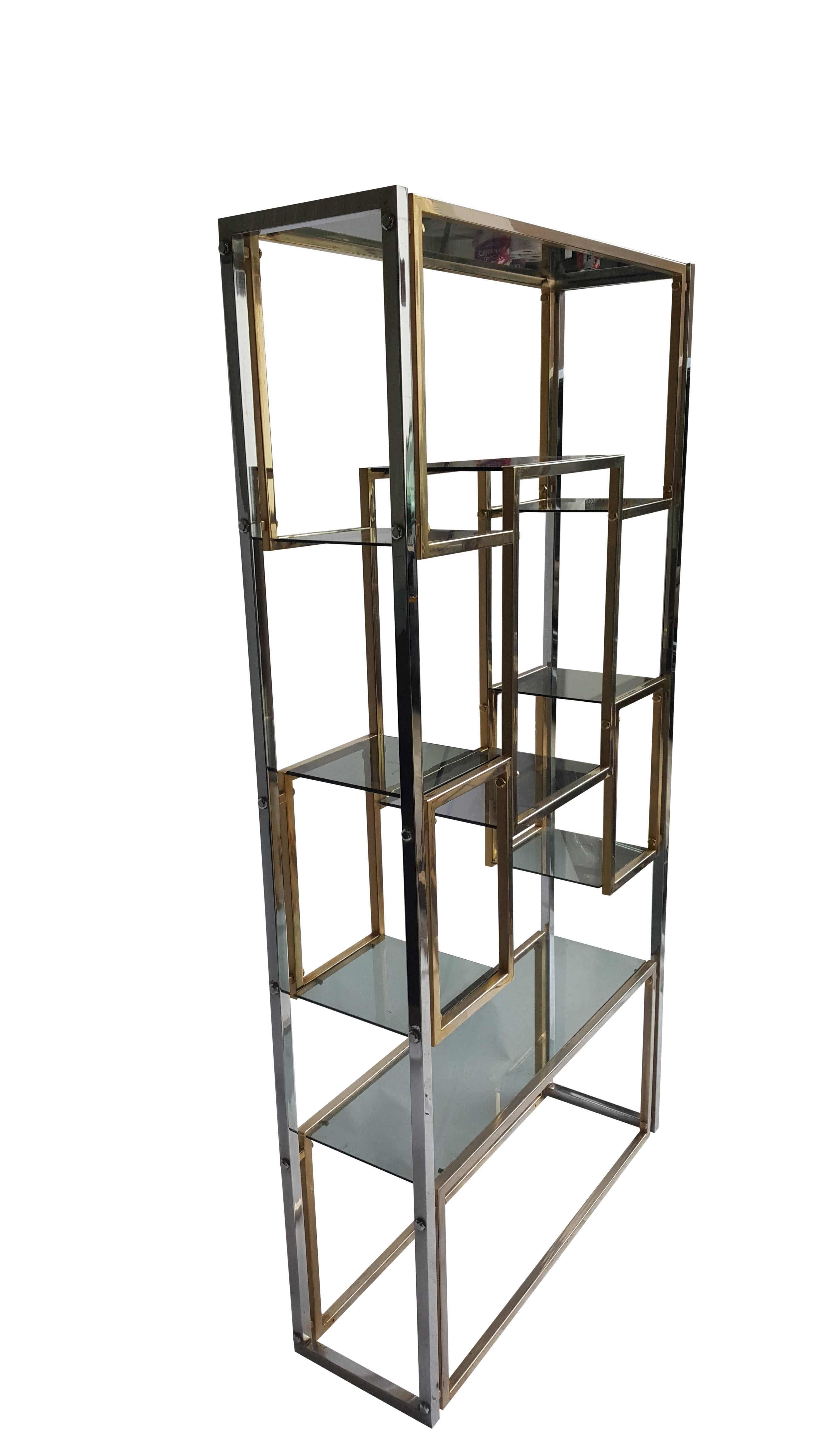 A good looking Hollywood Regency freestanding brass-plated etagere with a very nice original blue shaped glass. (Some little chip) 
Architecturally in the style of Romeo Rega, Hollis Jones, Maison Jansen.

1970s and possibly Italian in origin.

An