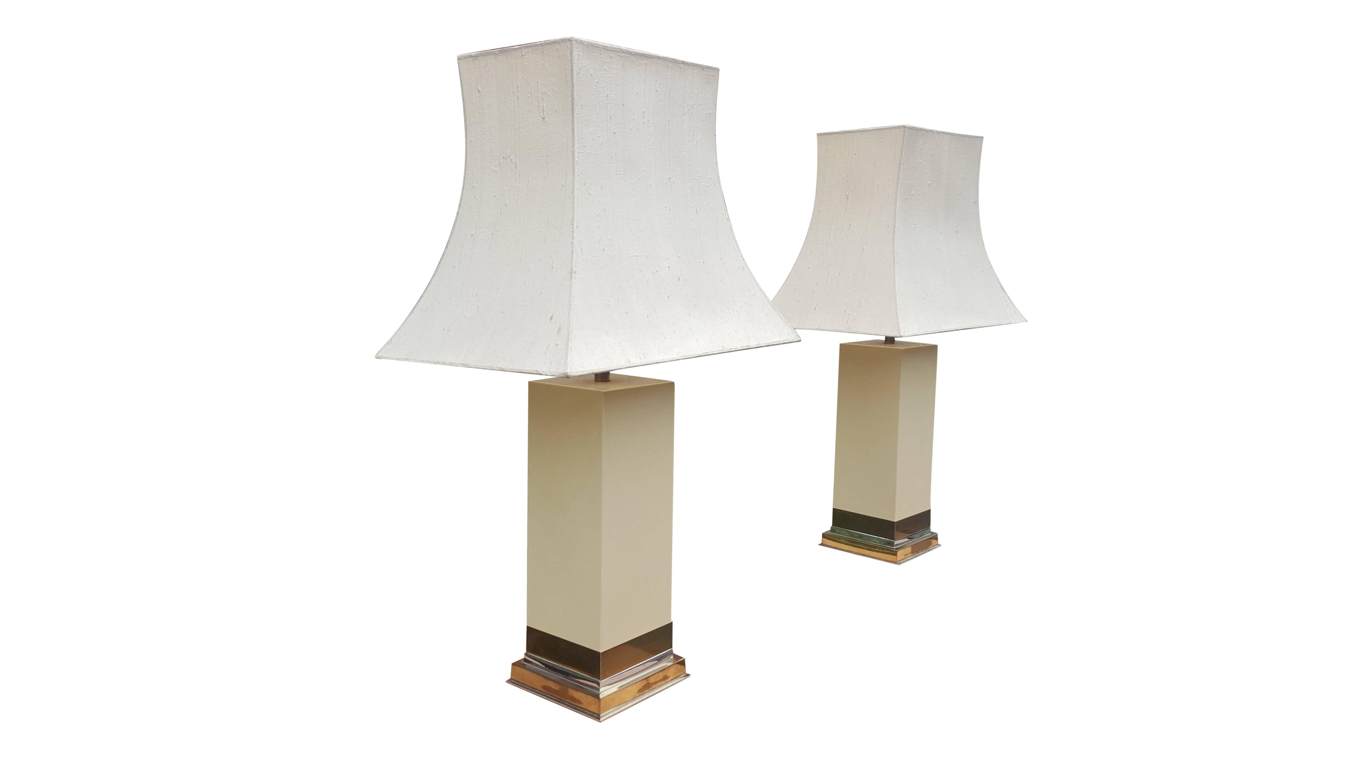 Handsome pair ivory lacquer table lamps.
Stepped plinth in alternating bands of nickel and brass.
Signed at the lower right 