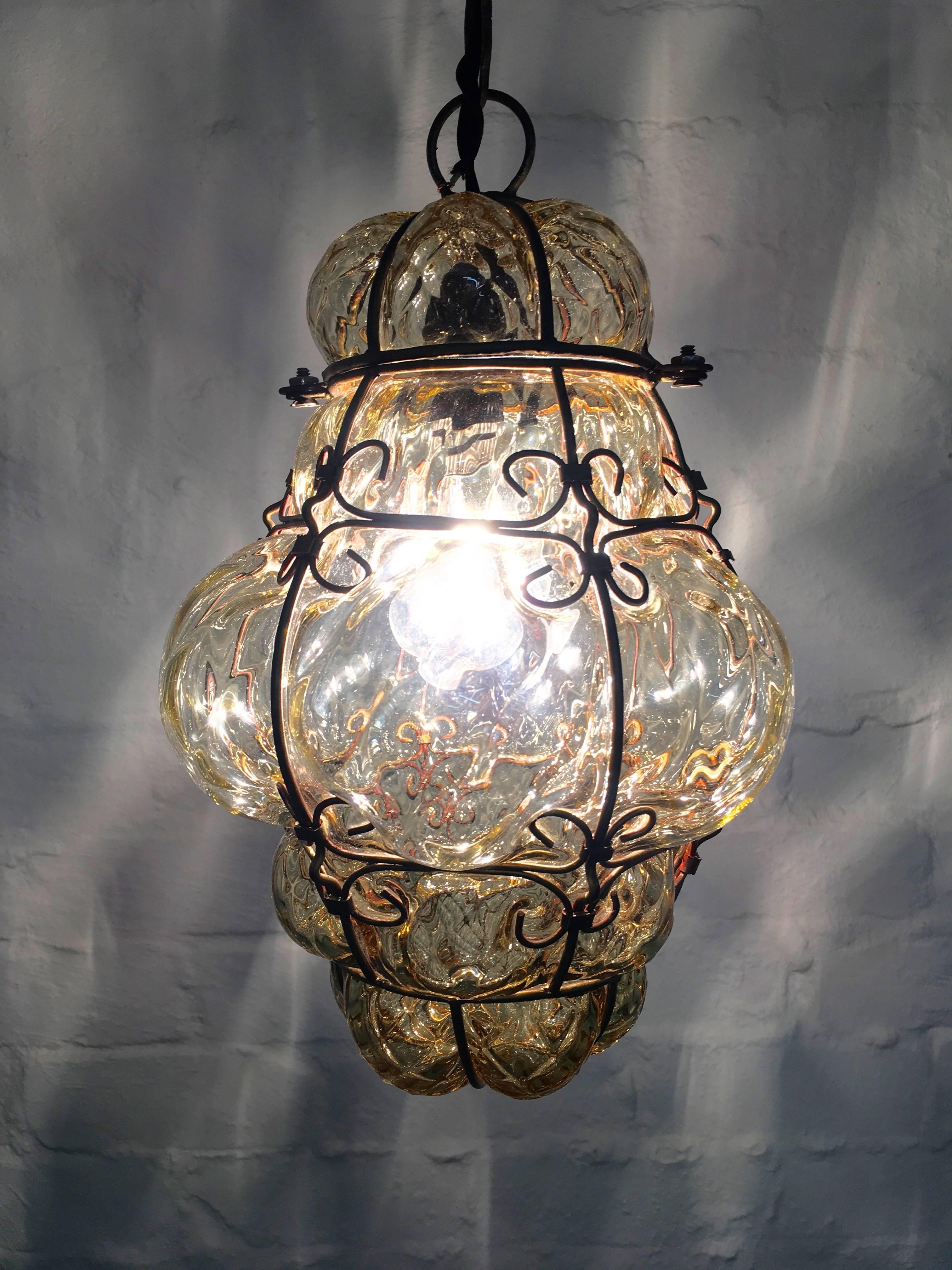A lovely light for hallways and entrances, this handblown glass lantern attributed to Seguso, casts a beautiful fishnet pattern on surrounding surfaces. The glass is a beautiful soft bronze-gold, not amber. As always, these lovely lanterns create