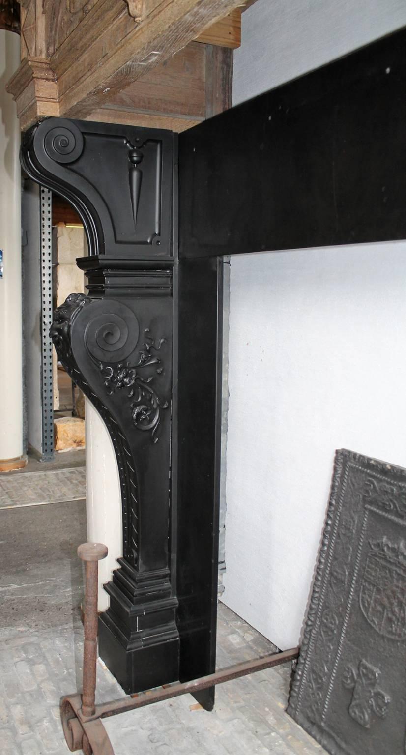 Blackened Antique Marble Fireplace with a Wooden Mantel on Top