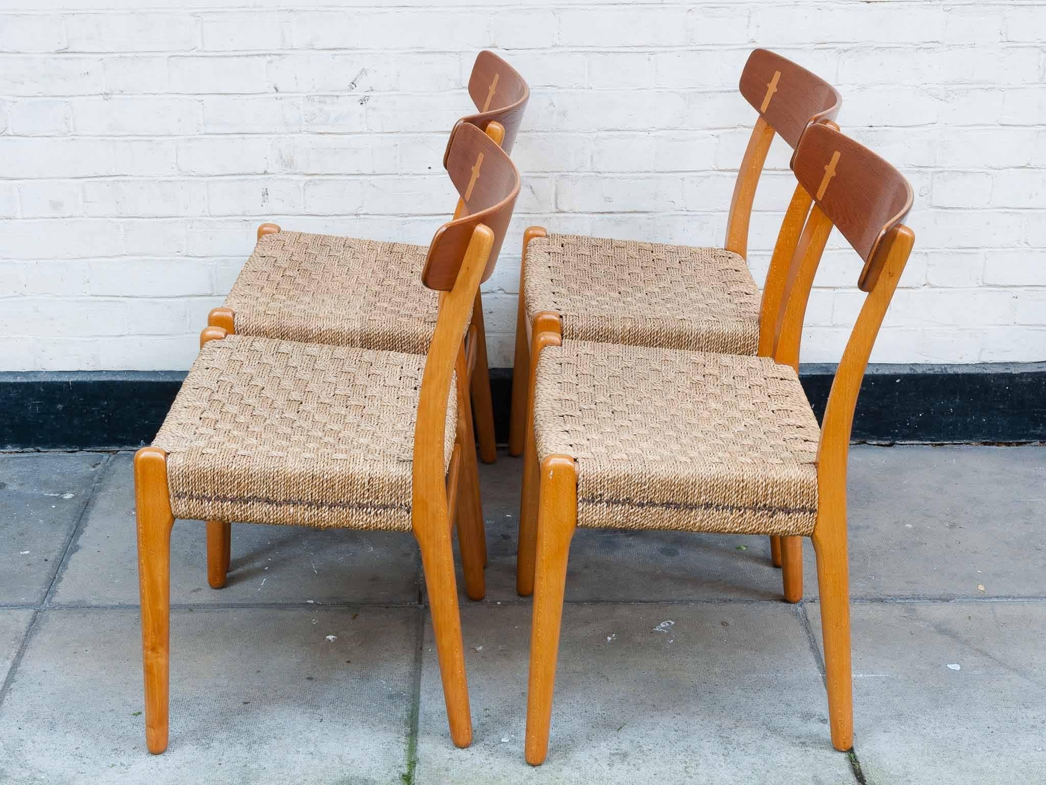 A stunning set of four Hans Wegner Teak and Oak Dining Chairs for Carl Hansen & Søn. The chairs which are made with solid Oak frames and feature Wegner's typical hallmark of an exposed joint that connects the rear shaft with the teak backrest