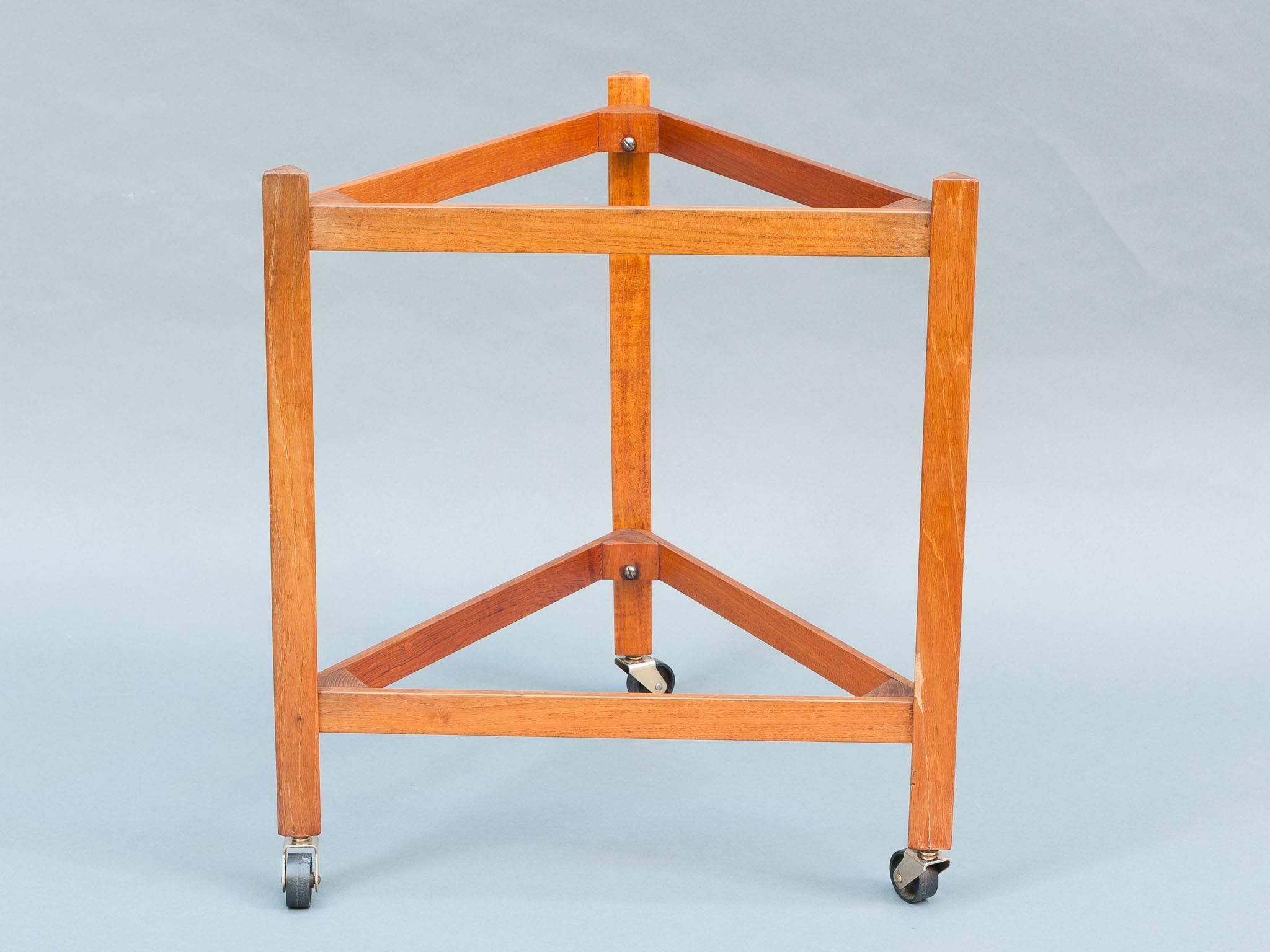 A fun and very practical teak serving drinks trolley with a pair of removable trays on the top and bottom. Manufactured in the 1960s by Sika Møbler in Denmark. The frame of the triangular trolley runs on three individual castors on the end of each