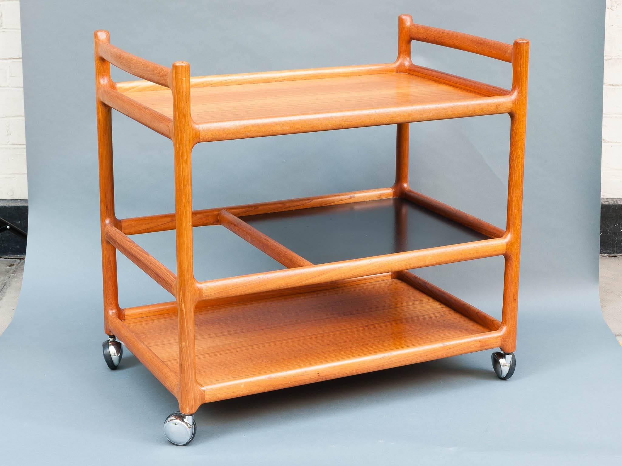 1960s Danish drinks trolley in a wonderful vintage condition designed by Johannes Andersen and manufactured by CFC Silkeborg Mobelfabrik. Made from solid teak and black laminate sitting on fully working chrome casters. A three-tiered trolley with a