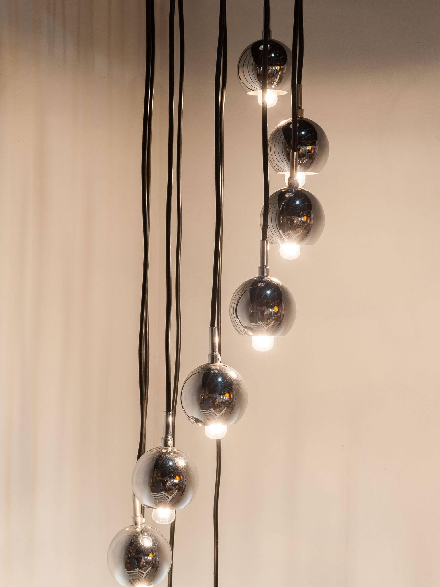 1960s ten chrome globe hanging light each one lower forming a long flowing spiral. Each globe hangs from a black flex and is 9cms in diameter. Perfect for a living room with a high ceiling or above a dining table or hallway. The wires are hidden