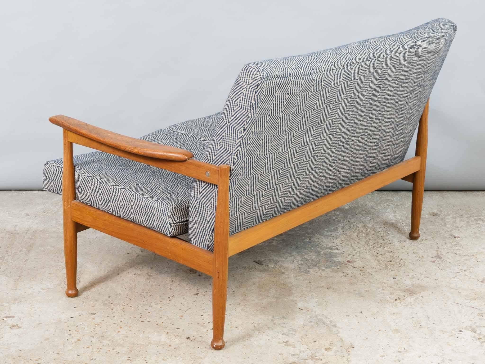 1960s, guy Rogers Afromosia Manhattan two-seat sofa with matching opening footstool. A well-designed and comfortable sofa with a high supportive back
and deep comfortable cushions. Sold by Heal's of London and designed by George Fejer/Eric