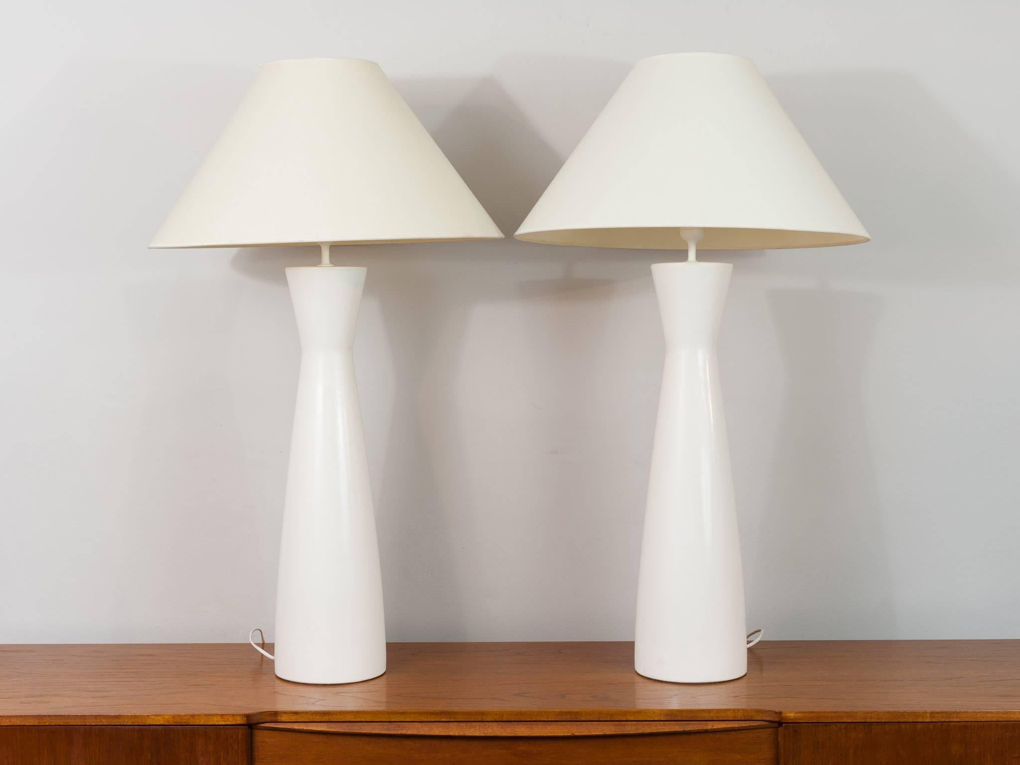 Vintage Belgium large off-white opaque glass lamps with their original shades. The base is formed from one piece of cased glass giving the impression that it's ceramic with a white plastic single bulb holder at the top of each lamp to hold the shade