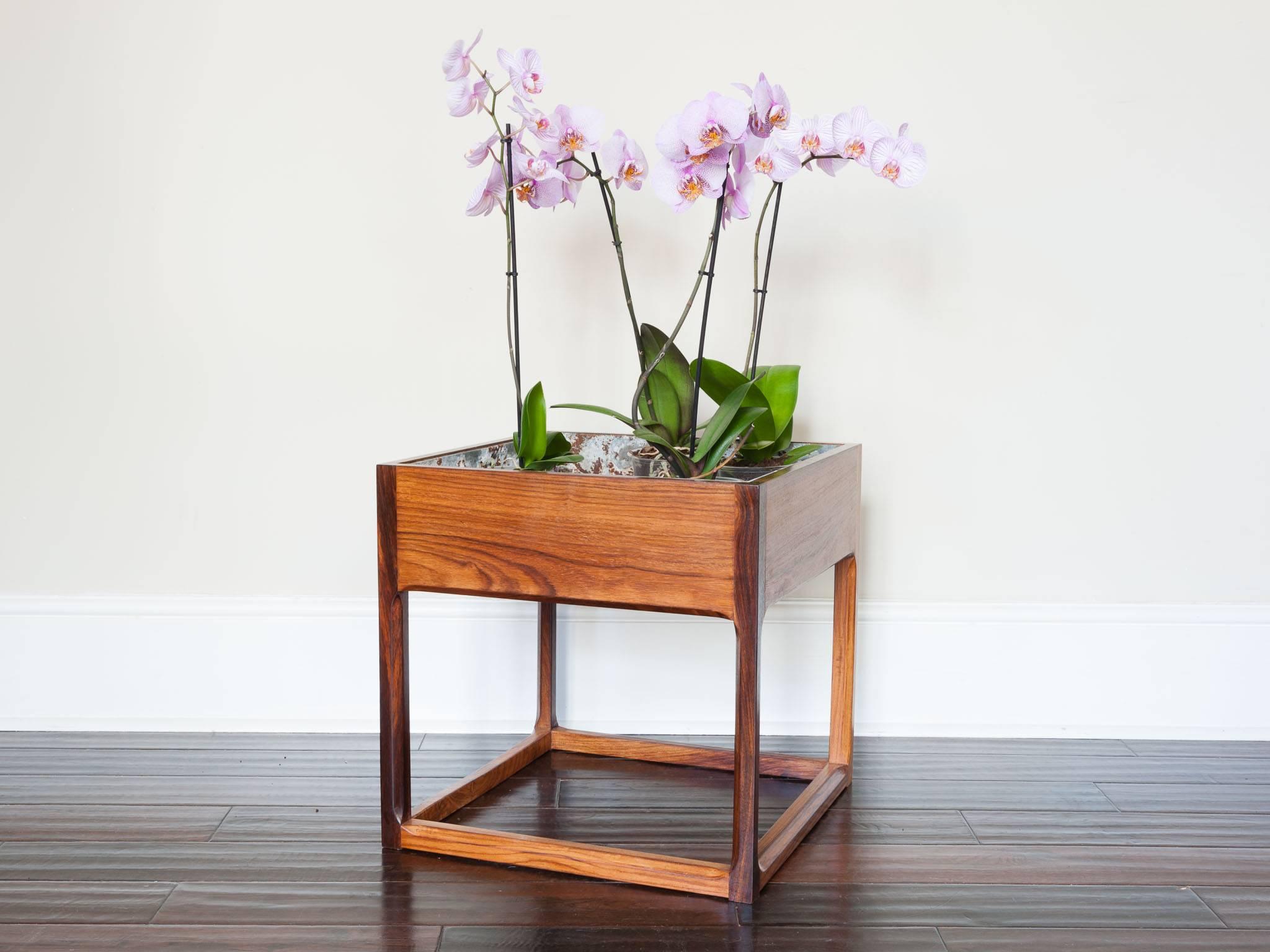1960s Danish rosewood cubic planter with feature chamfered legs. The metal liner is easily removed with two handles however it is not water tight and is rusty in places as shown in the images. The planter is made of rosewood veneer with solid legs