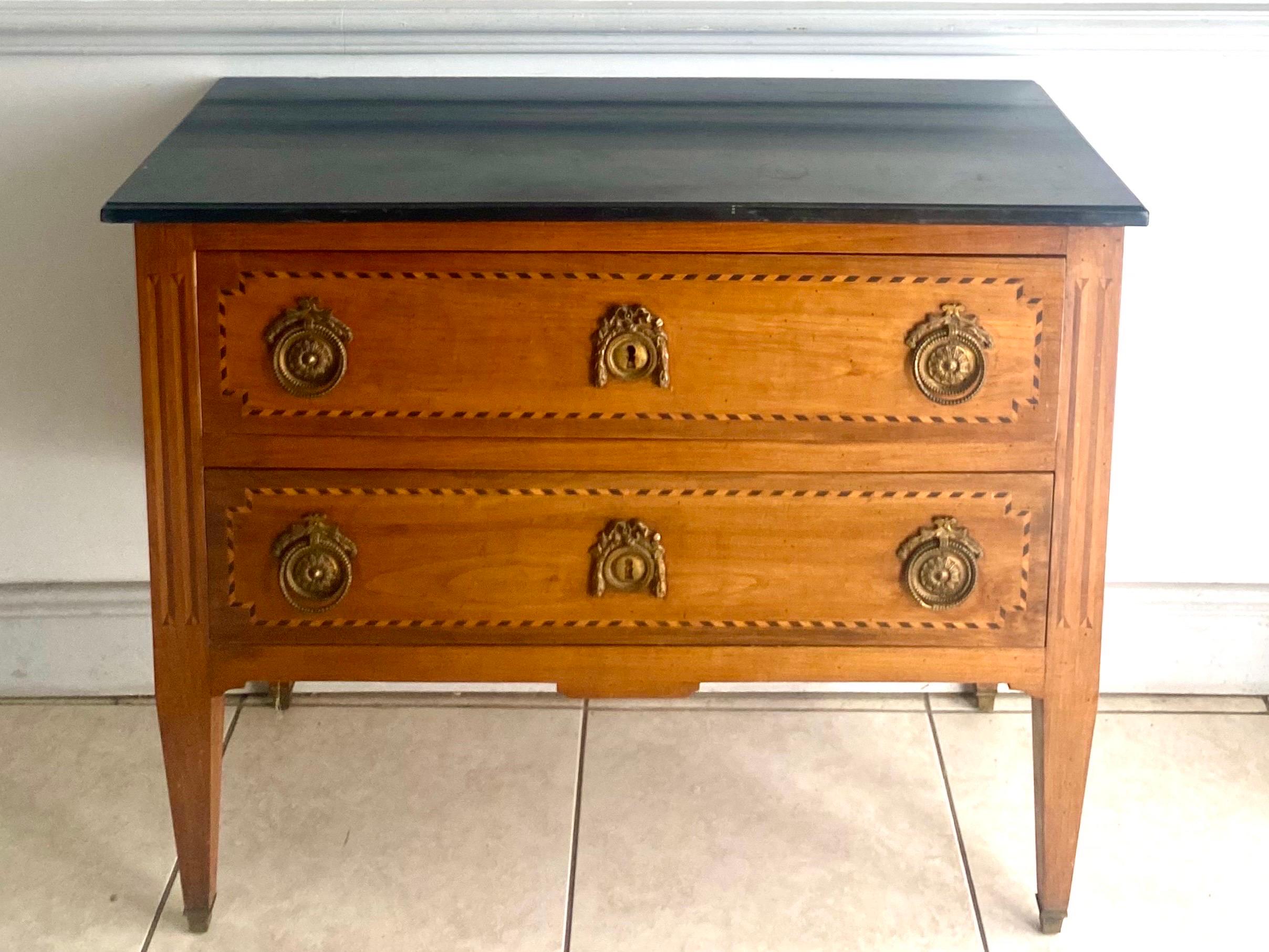 Wonderful French chest of drawers from the Louis XVI period, 18th century, with a rectangular black marble top surmounting two drawers, each with two ring handles, resting on square conical legs with bronze shoes.
Its facade is straight.

This