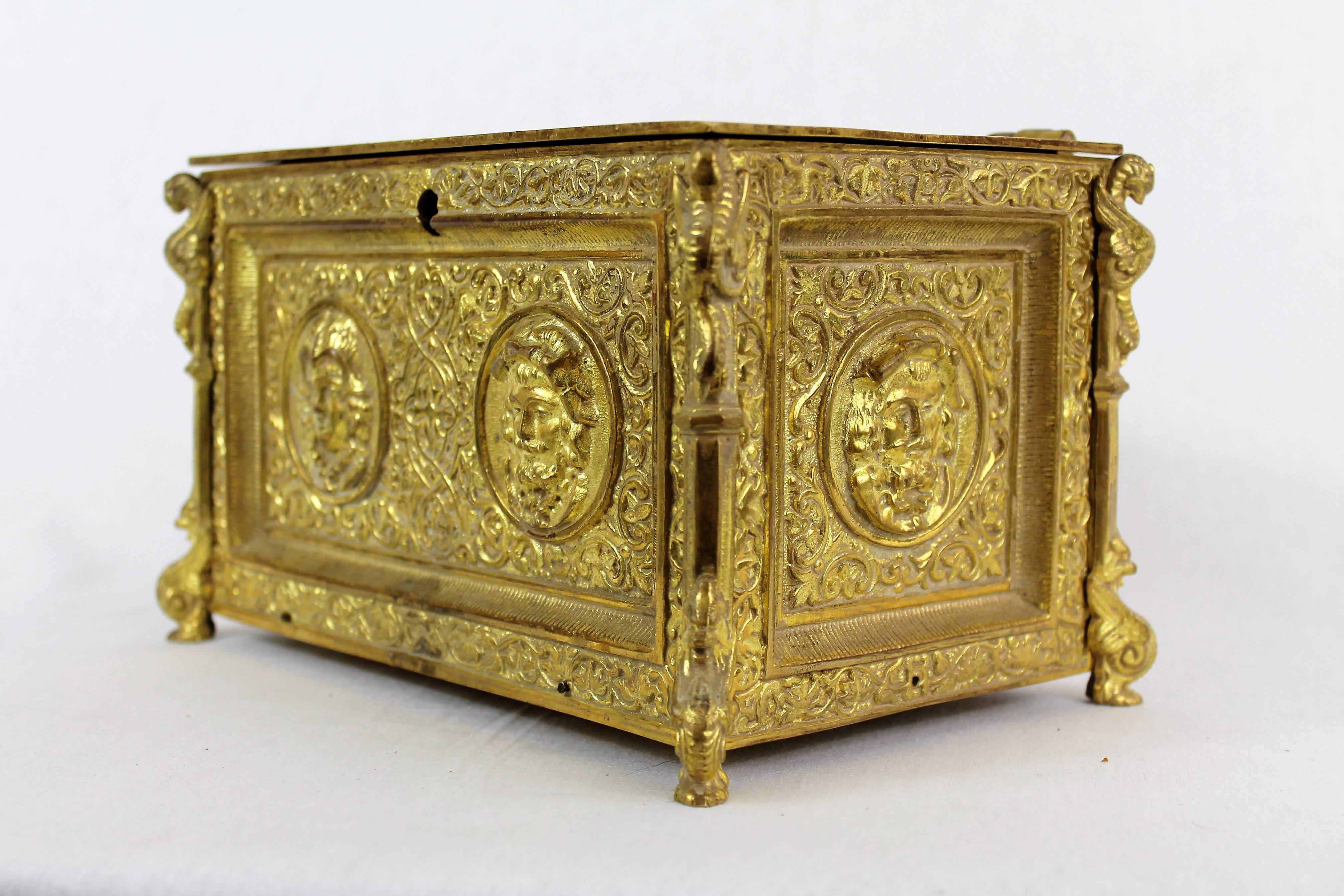 Beautiful gilt bronze jewelry box in Renaissance style decorated with medallions of portrait of men and women, surrounded by foliage. The posts are decorated with sphinxes and chimeras. The interior is trimmed with mahogany inserts.