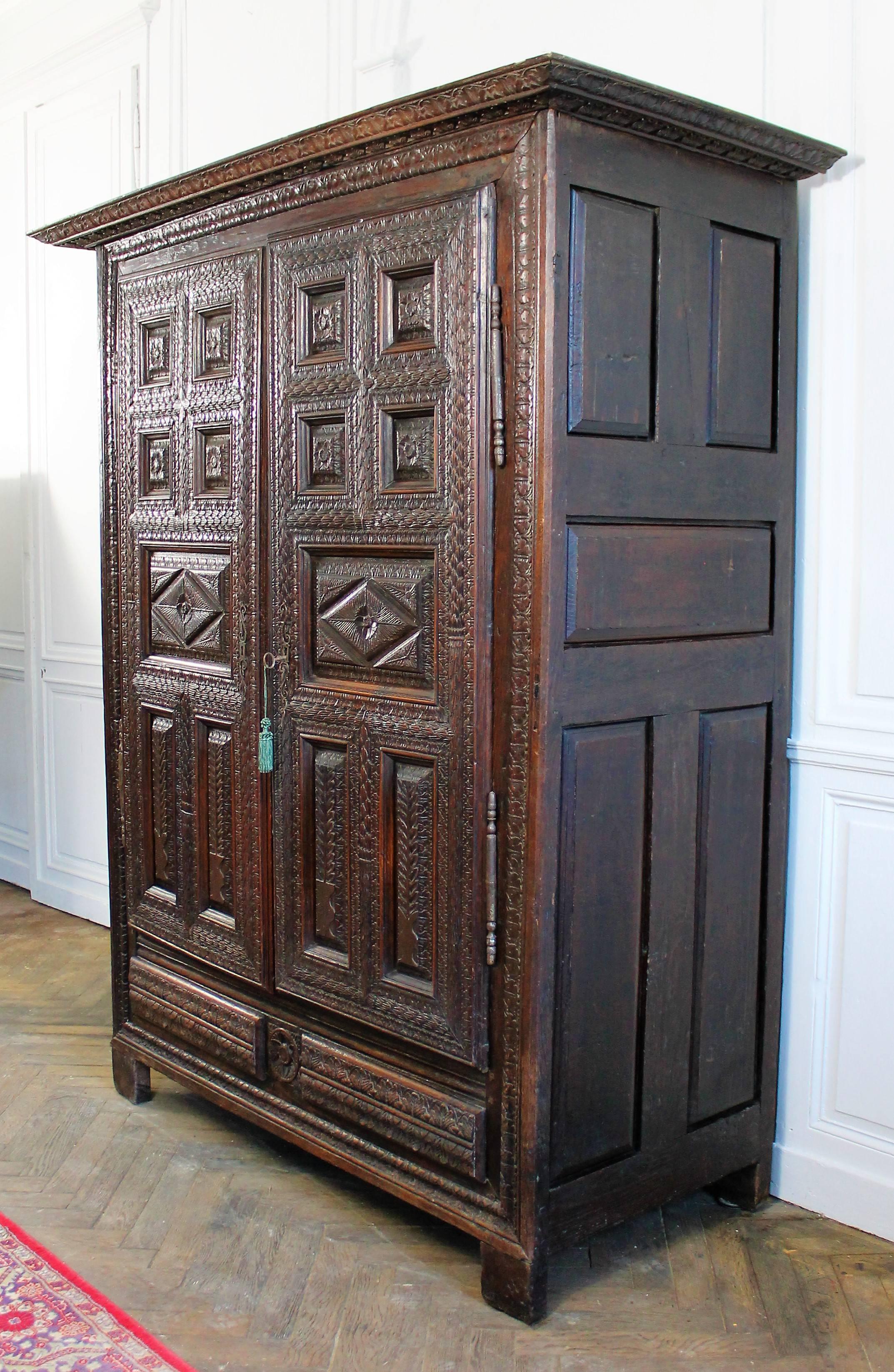 17th century carved chataignier wood opening with two doors in front, molded and richly hand-carved. The doors are parquet and compartmentalized in several reserves: four in the upper part with flower motifs, a central panel also with floral
