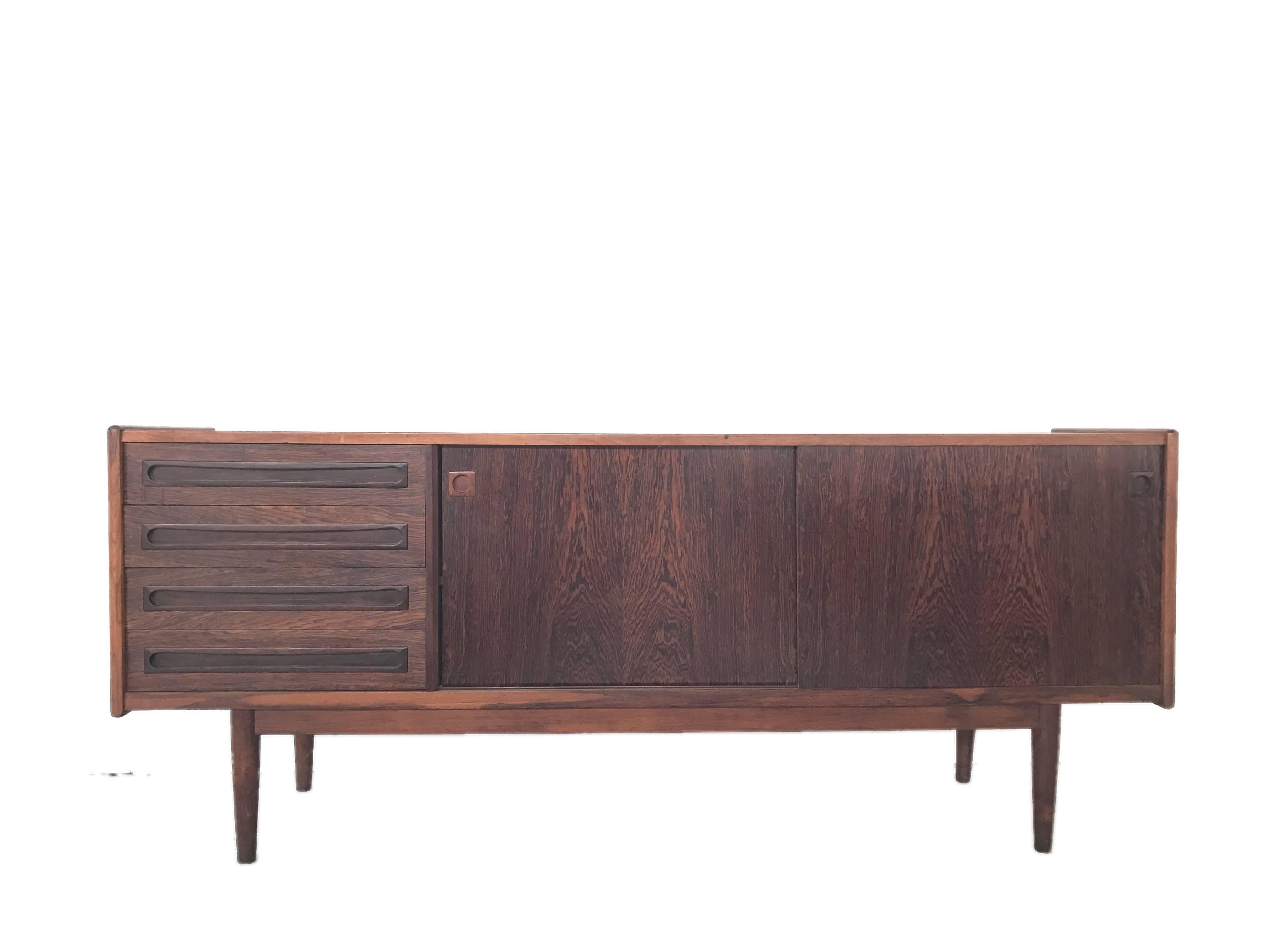 A beautiful rosewood Scandinavian dresser. This credenza is attributer to Ib Kofod-Larsen and is signed with a sticker of Danish control.
Four drawers and two sliding doors.
Leggs can be easily removed for mounting on the wall.