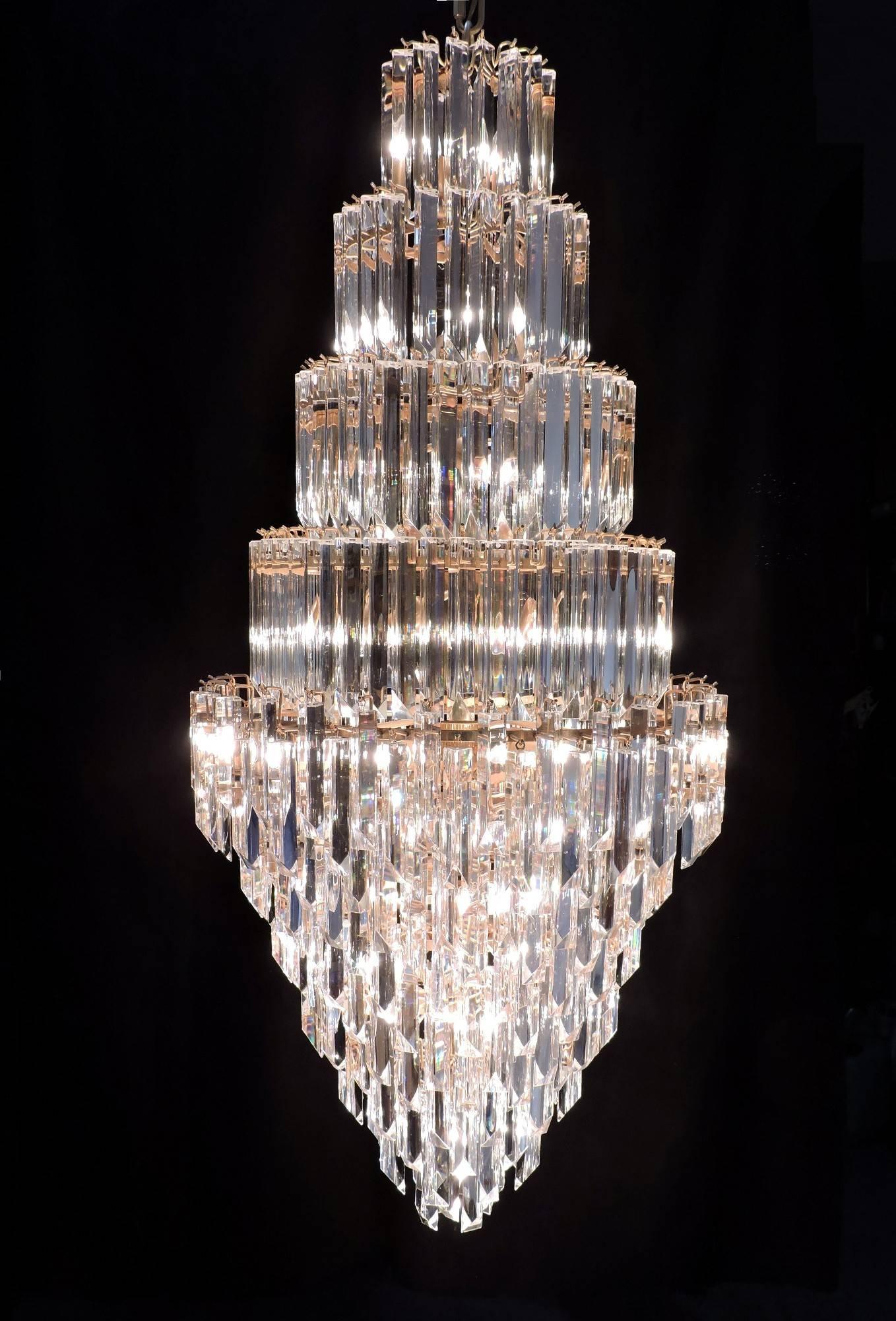 Spectacular Murano multi-tiered glass prism chandelier. This huge light fixture is almost 5 feet high and has hundreds of high quality three-sided prisms arranged in layers on a brass framework. It takes twenty-three 60 watt max standard base bulbs.