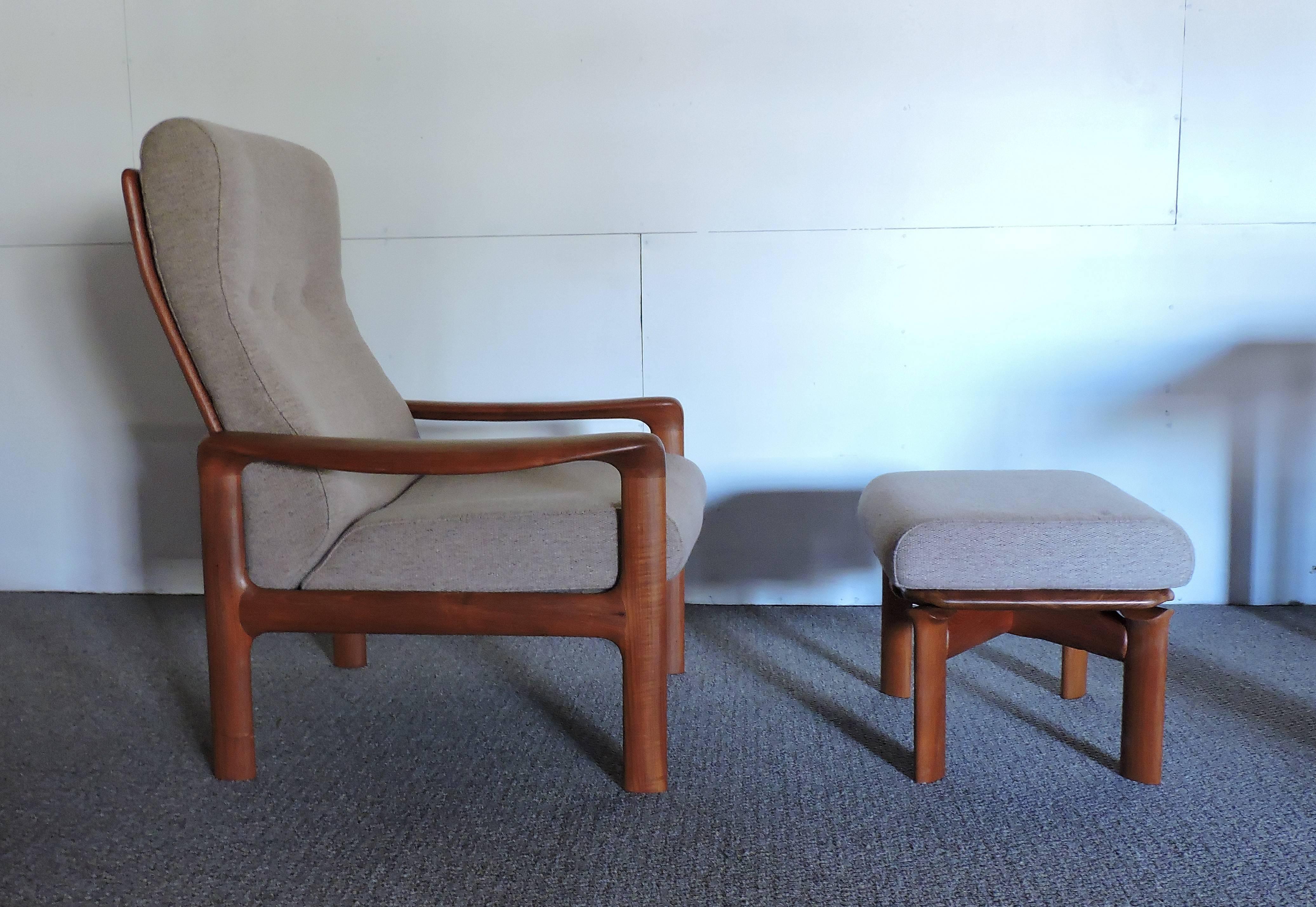 Extremely comfortable high back lounge chair and ottoman made by Komfort of Denmark. This sturdy and well made chair has a solid teak frame with beautiful sculpted arms, a curved slat back, and the original light tan upholstery.
Excellent