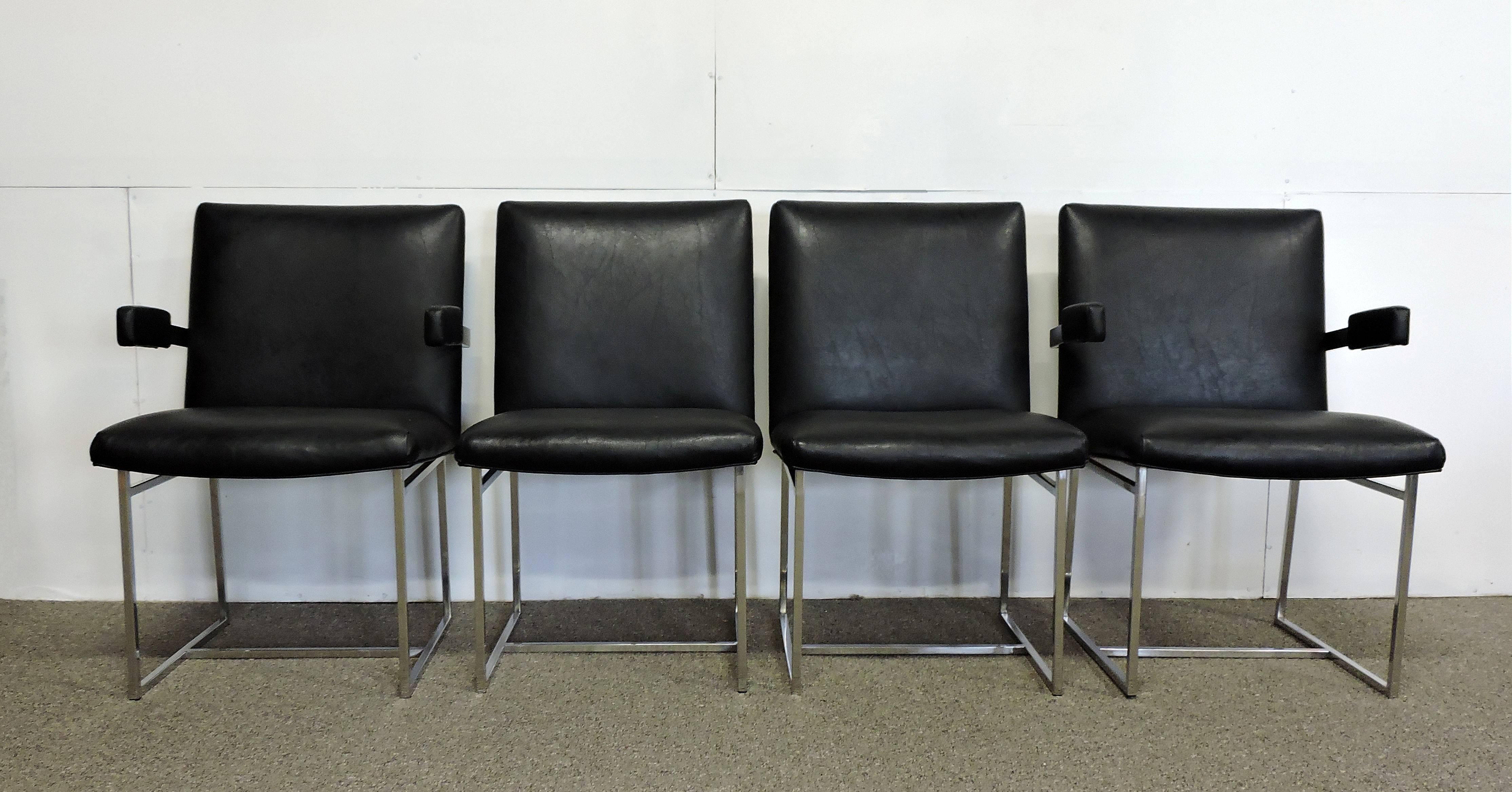 Beautiful set of four Milo Baughman dining chairs. These heavy and well made chairs have a clean, Classic look with thin chrome frames and black Naugahyde upholstery. This set includes two arm chairs and two side chairs.