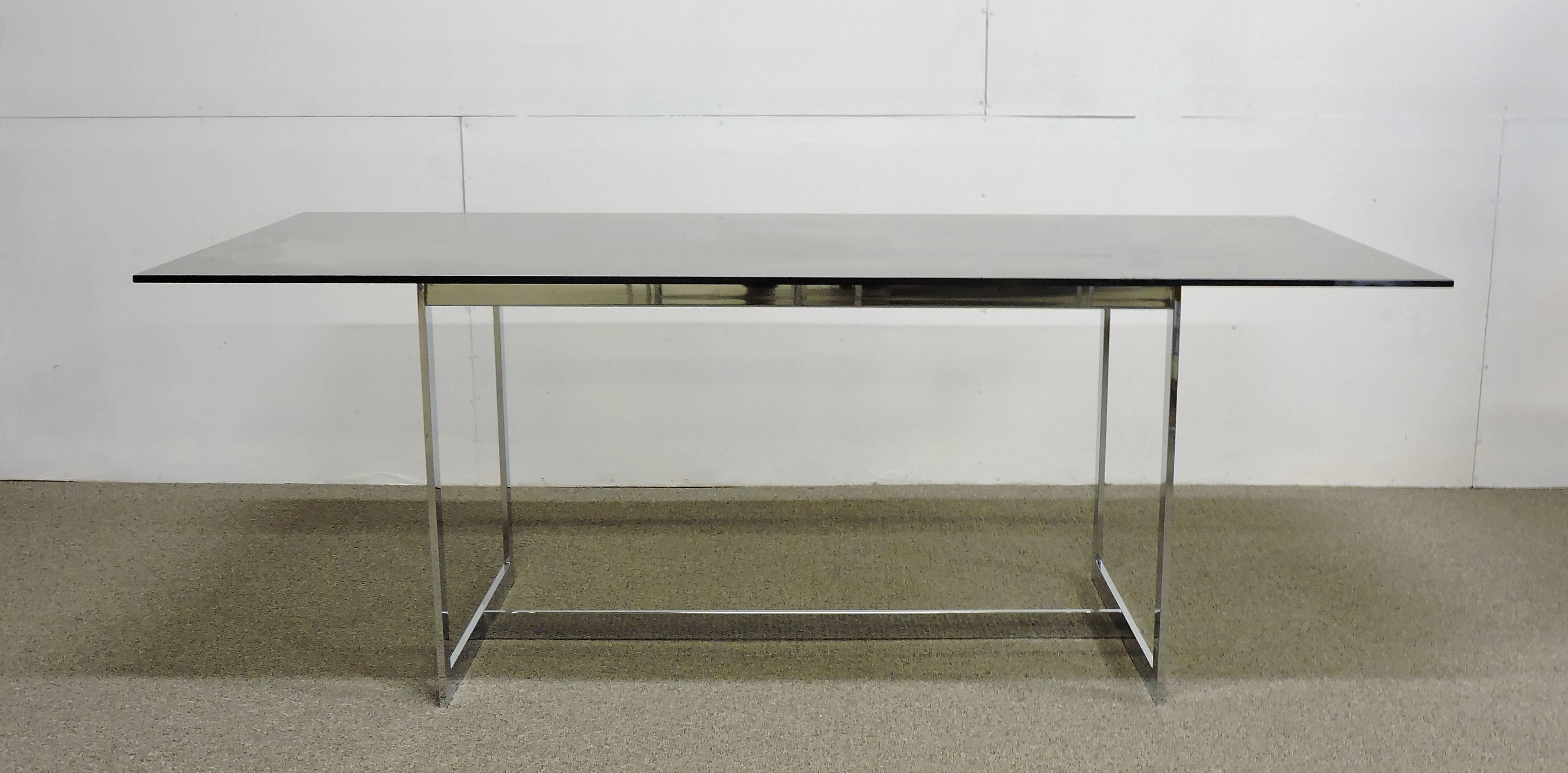 Smoked gray glass and a thin chrome base give this table designed by Milo Baughman a light and airy look. The table has a half-inch thick glass top that sits on top of an architectural style base. Also makes a great desk! Pictured with a set of six