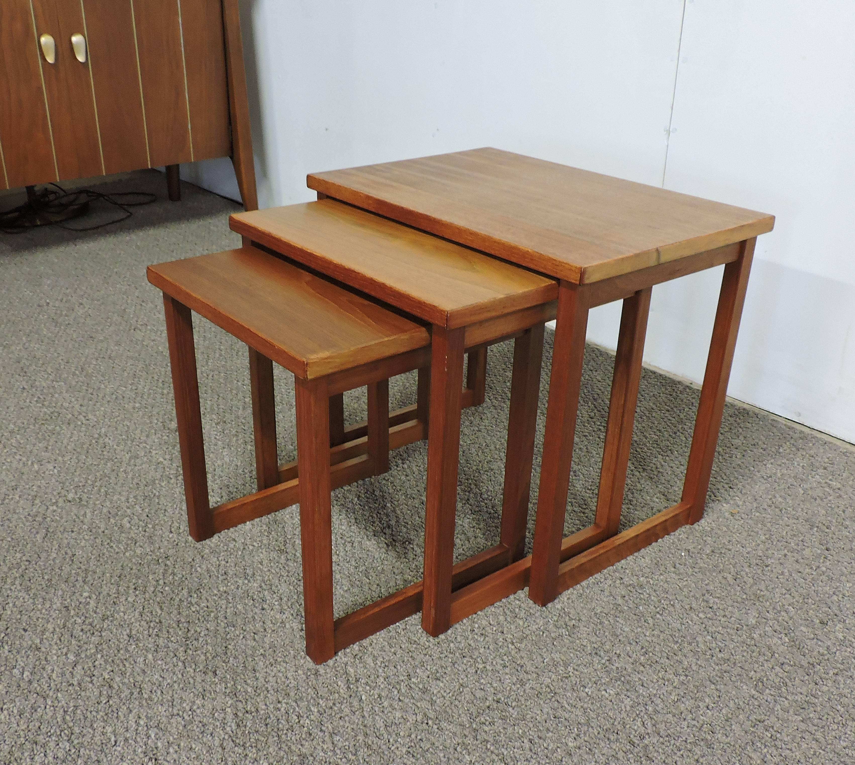 A set of three Danish teak nesting tables very similar to ones designed by Svante Skogh. These versatile tables have solid teak legs and are great for small spaces. Stamped made in Denmark, the dimensions are for the largest table.