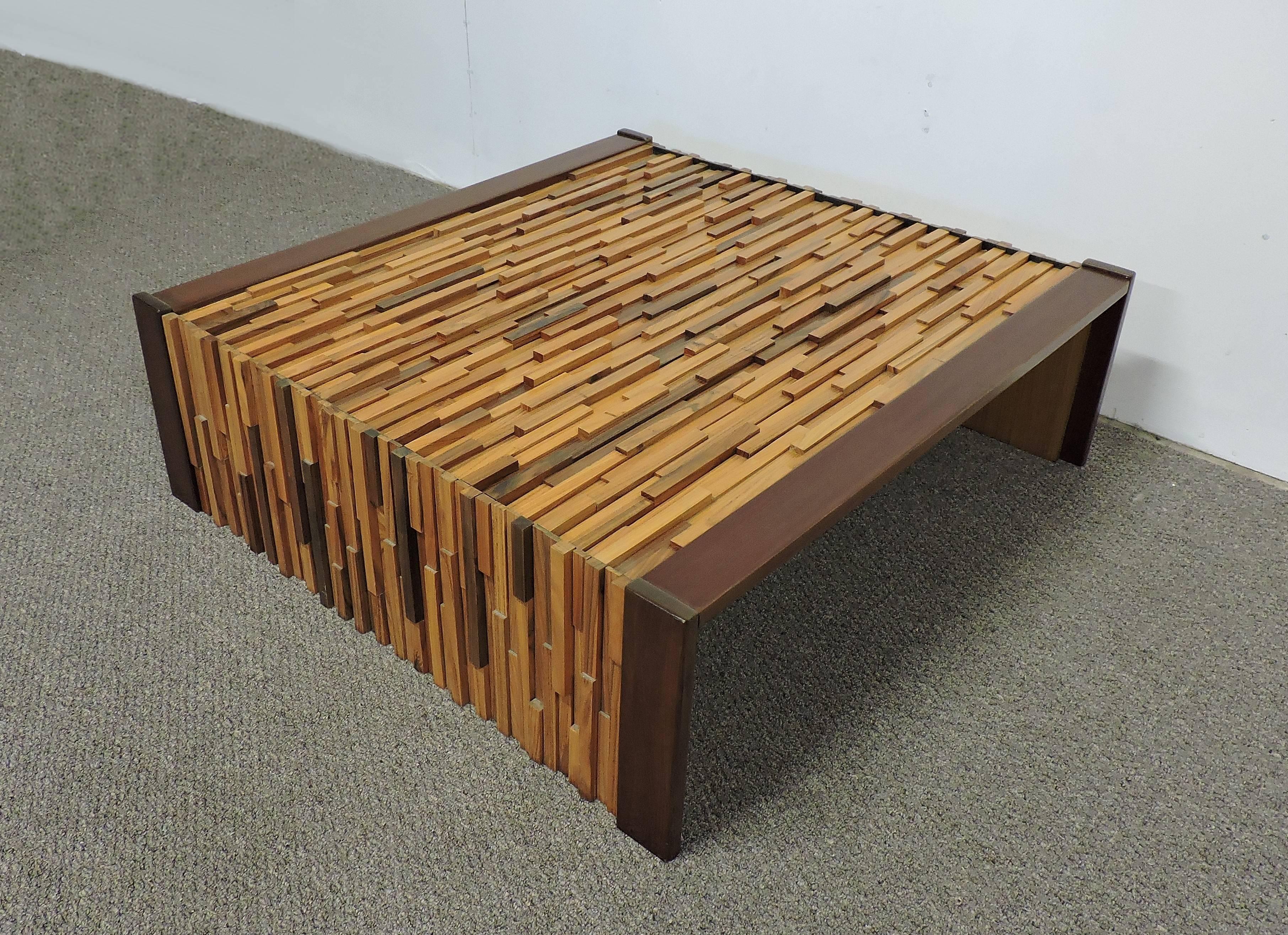 Unique and large coffee or cocktail table designed by Percival Lafer and made in Brazil. This table is made of varying lengths of exotic wood blocks giving it a very sculptural look and has rosewood edges for contrast. Included is the original glass