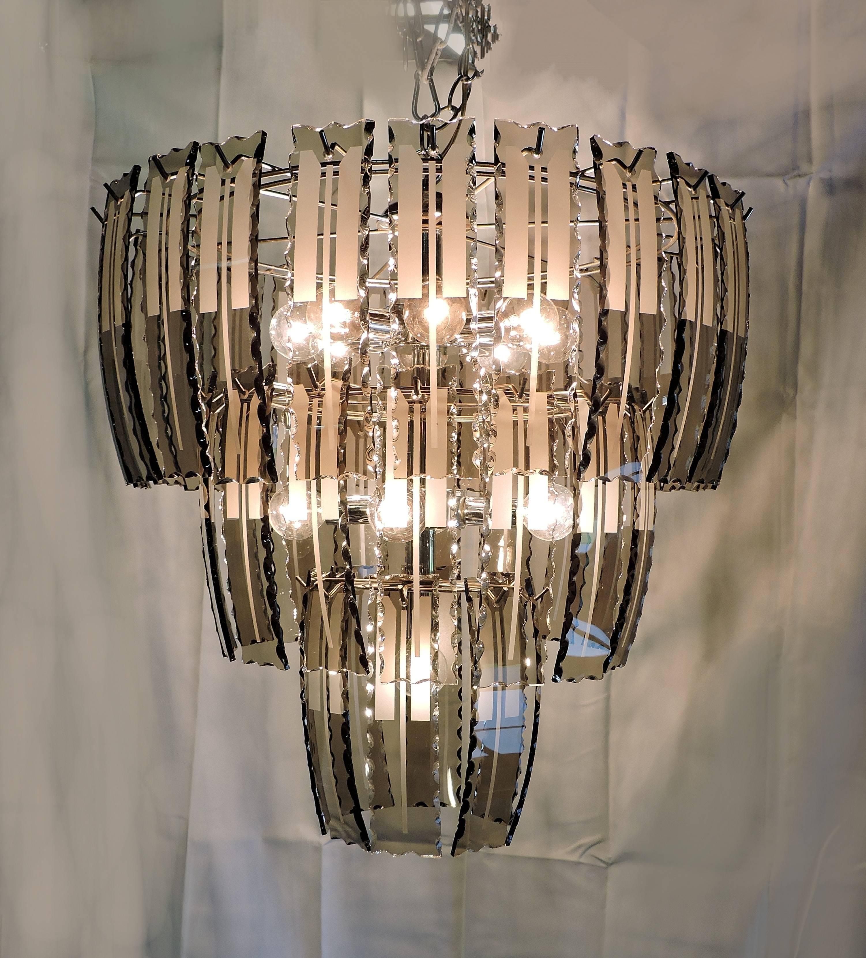 Beautiful Fontana Arte style chandelier with three tiers of curved smoked and etched glass panels. Serrated edges to the glass give added texture and sparkle. This fixture takes 13 candelabra base bulbs, has a long chain for hanging, and also