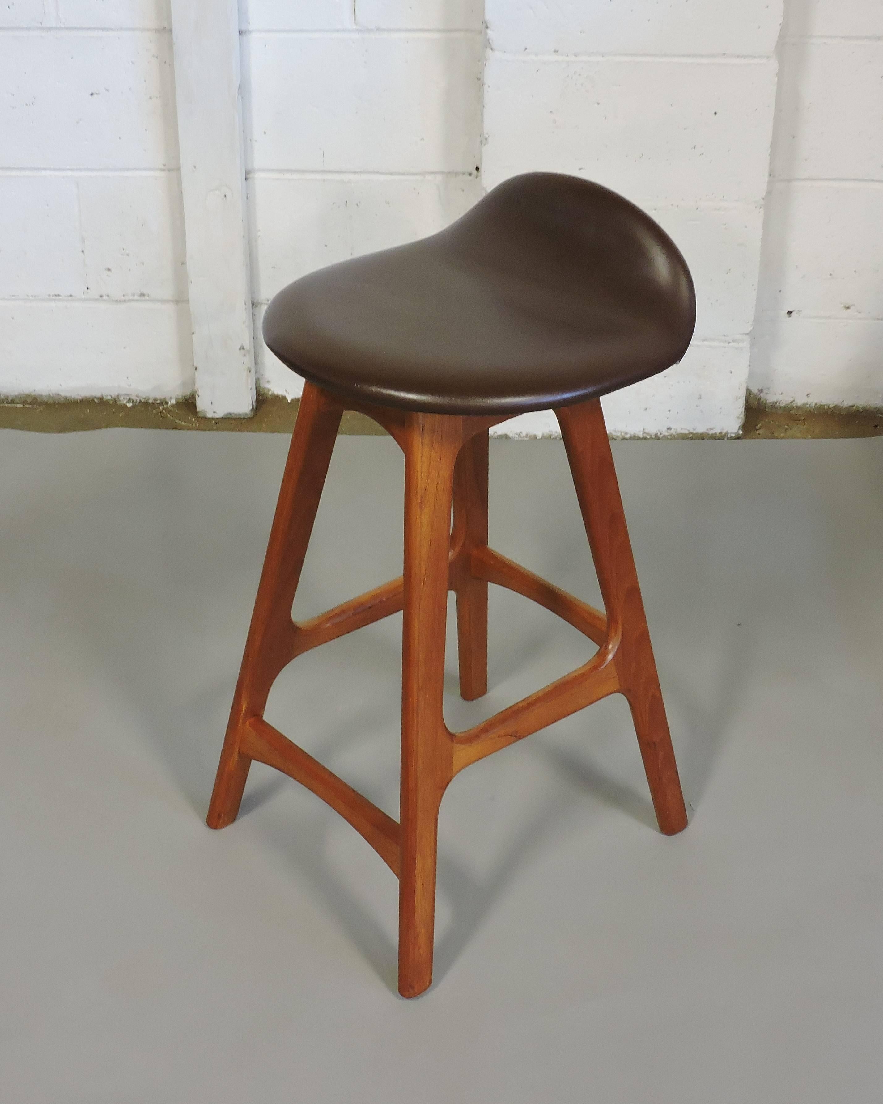 Sleek Danish modern counter stool designed by Erik Buck and made in Denmark by O.D. Mobler. This stool is made of solid sculpted teak and has a curved brown Naugahyde upholstered seat.
