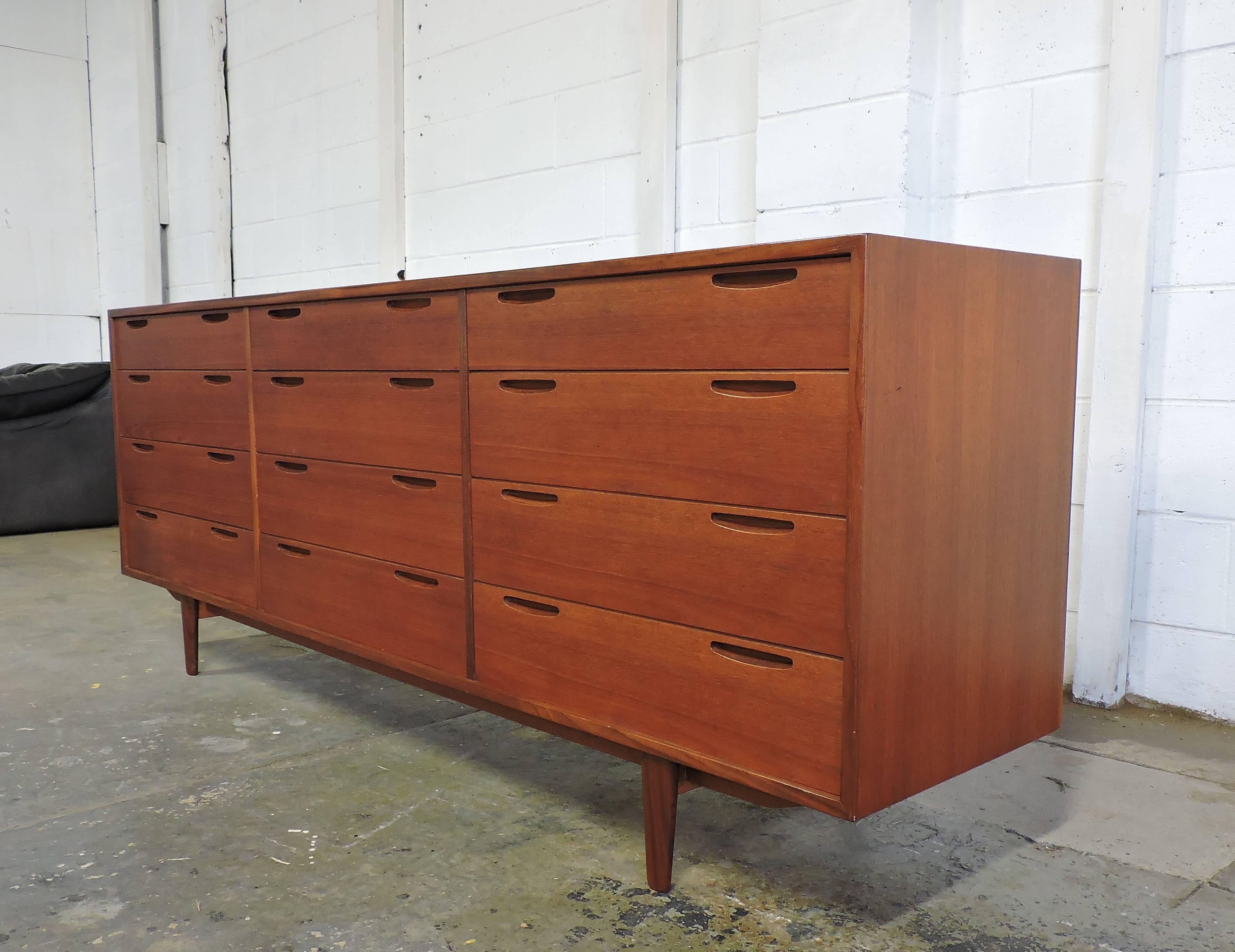 Handsome and hard-to-find triple dresser designed by Ib Kofod Larsen and made in Denmark by Brande Mobelfabrik. This dresser has plenty of storage with twelve dovetailed drawers that have sleek, Minimalist inset pulls. Very well constructed, it also