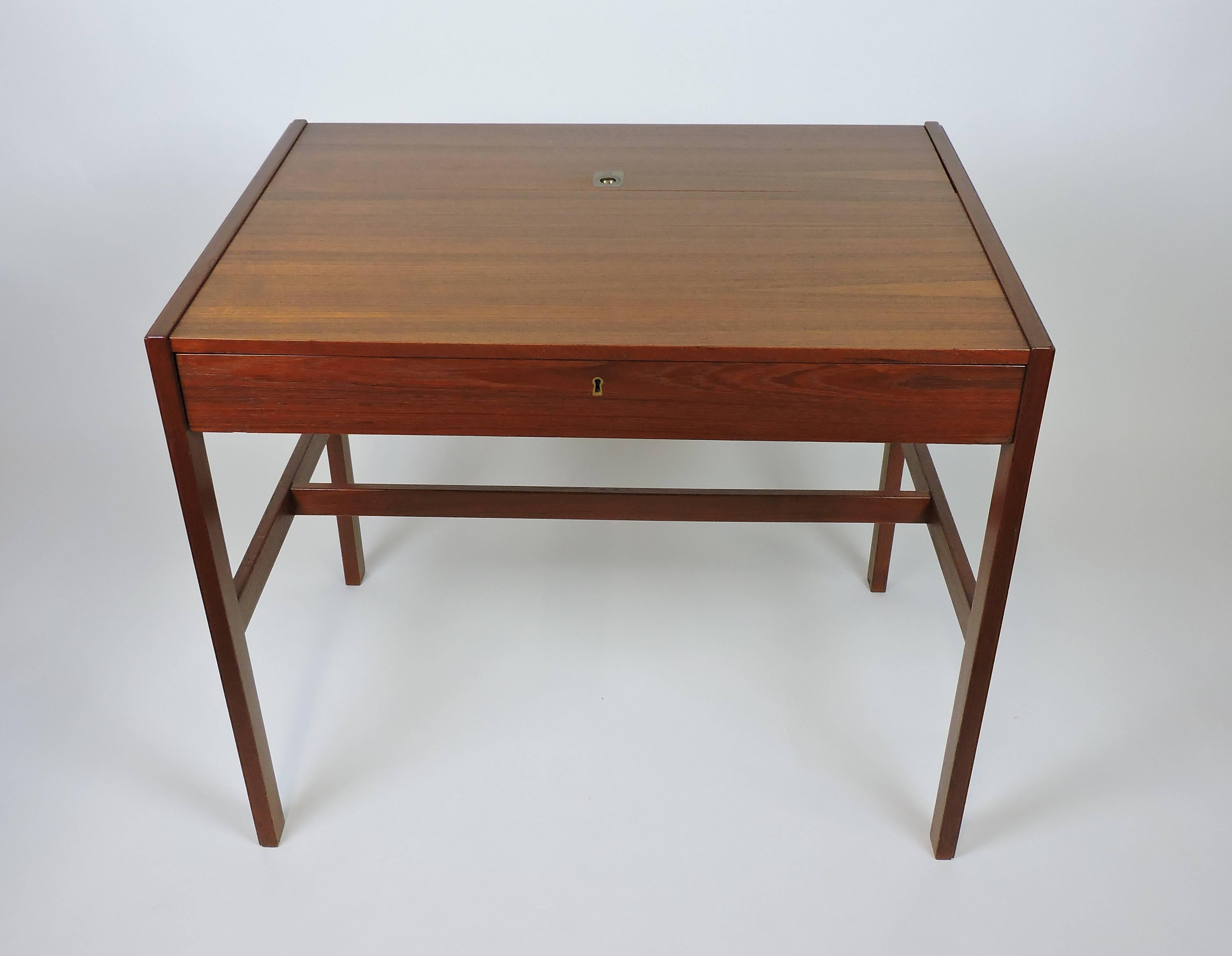 Simple and elegant hard-to-find teak desk designed by Arne Wahl Iversen and made in Denmark. This desk can also be used as a dressing table, and has wonderful features that include a locking pull out drawer, a large writing surface, and a hidden