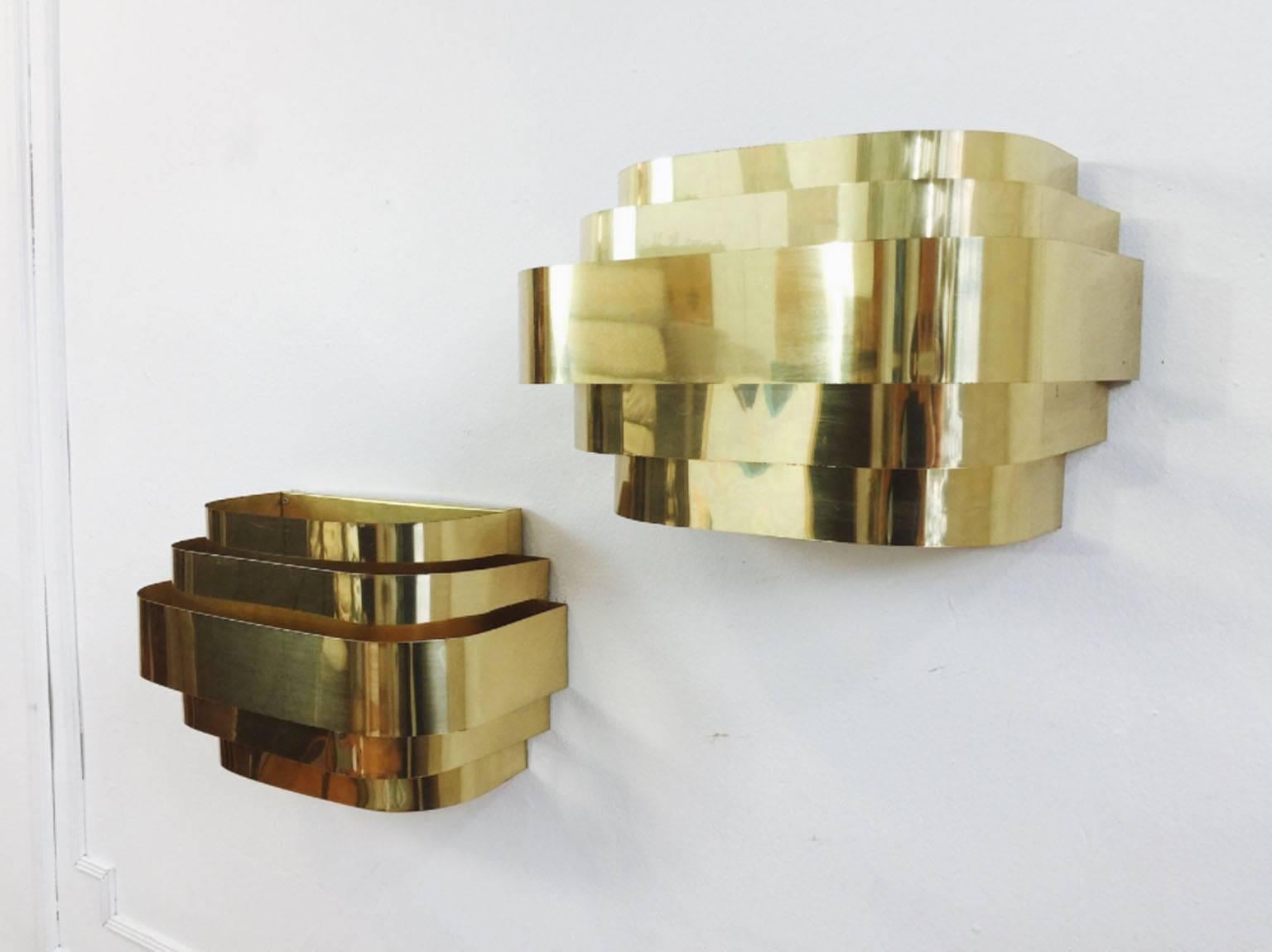Pair of Lightolier style, Mid-Century Modern, brass-plated cascade wall sconces. Art Deco or Hollywood Regency style. Both pieces are in excellent vintage condition with light staining on inside surfaces.

Wiring and light bulb sockets are not