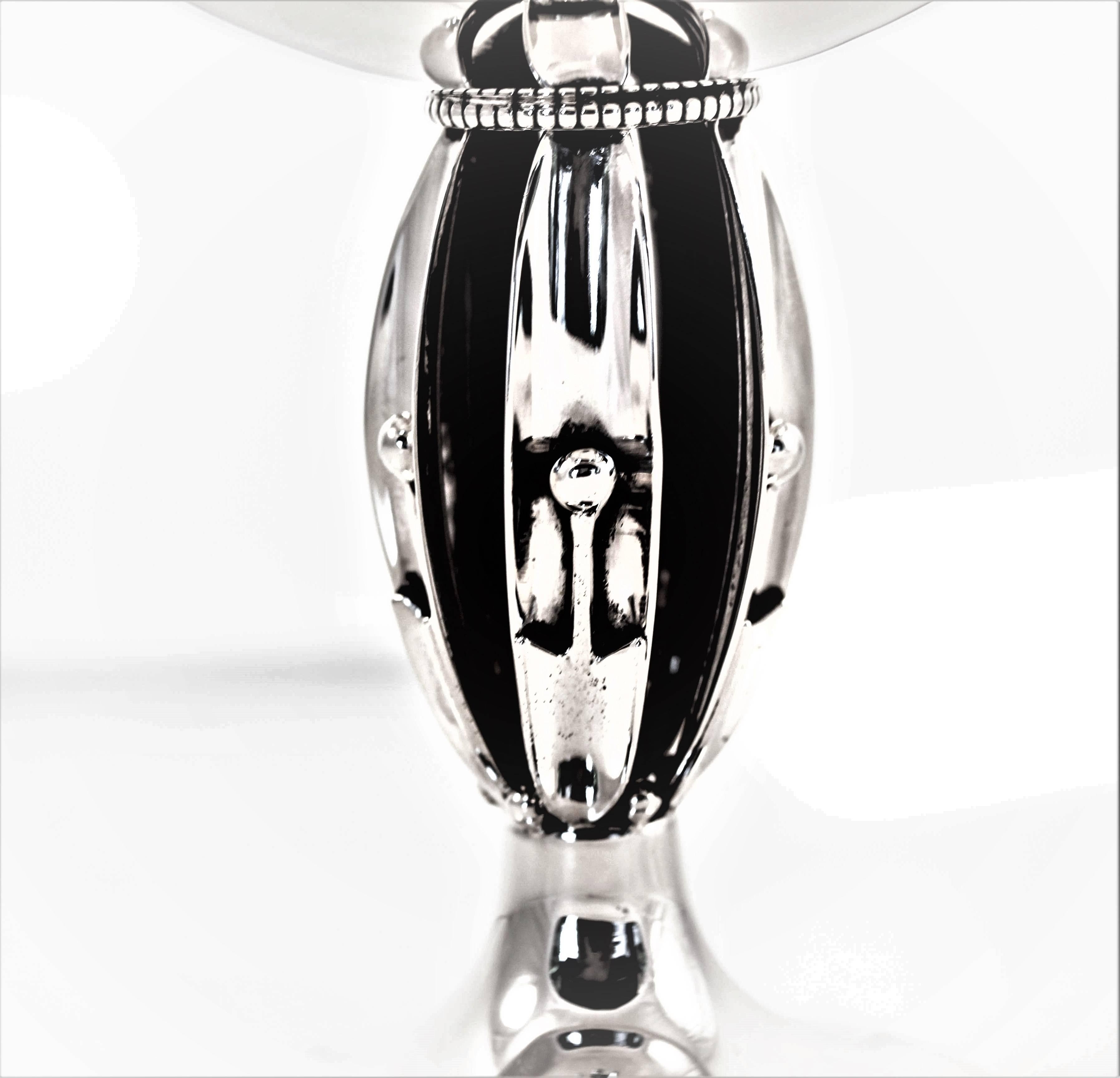 This compote has a modern, “clean” look with an interesting modernism design in the body. Five strips of silver connect the base with the top. The center is hollow. In the middle of each strip a ball is seen, in addition there is a ball in between