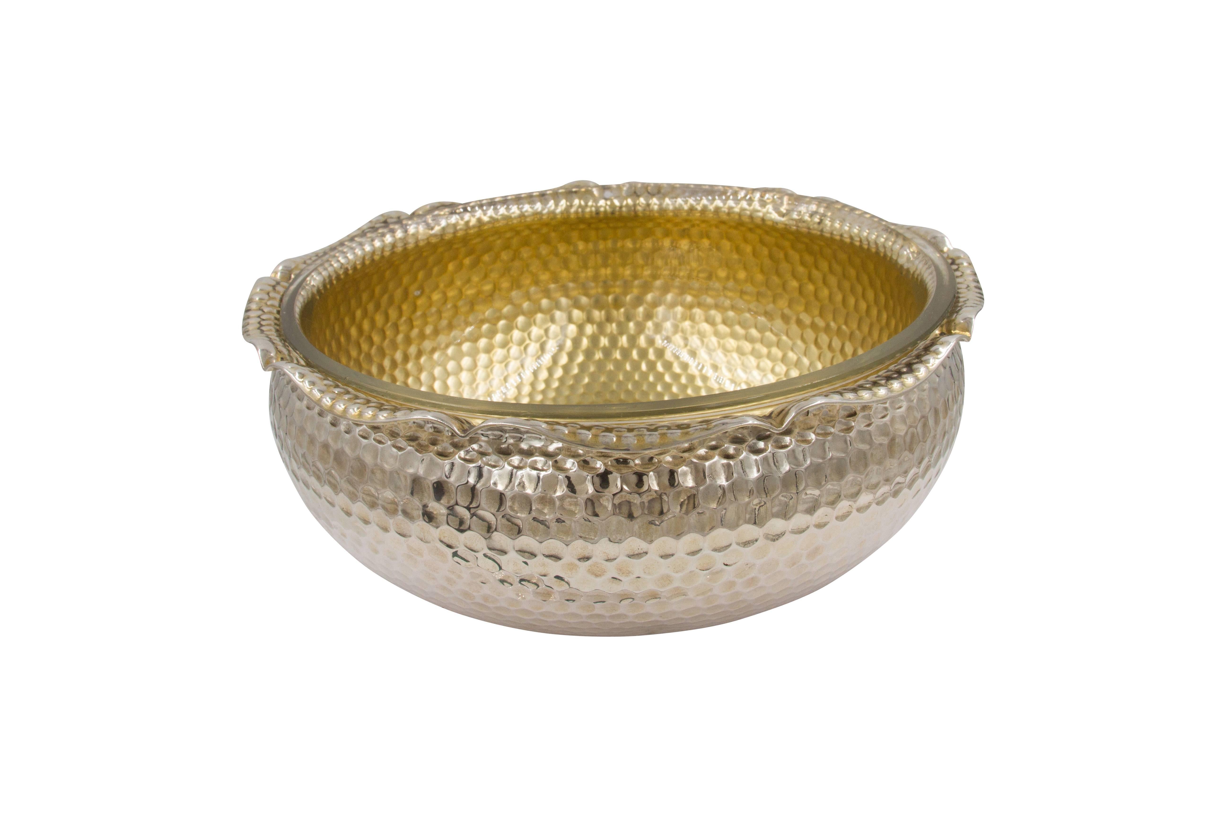 The pebble-like exterior of this hammered bowl brings a rustic yet elegant sensibility to your home. You can fill it with anything, even the most acidic foods because there's a removable glass liner (original) that protects the silver and makes for