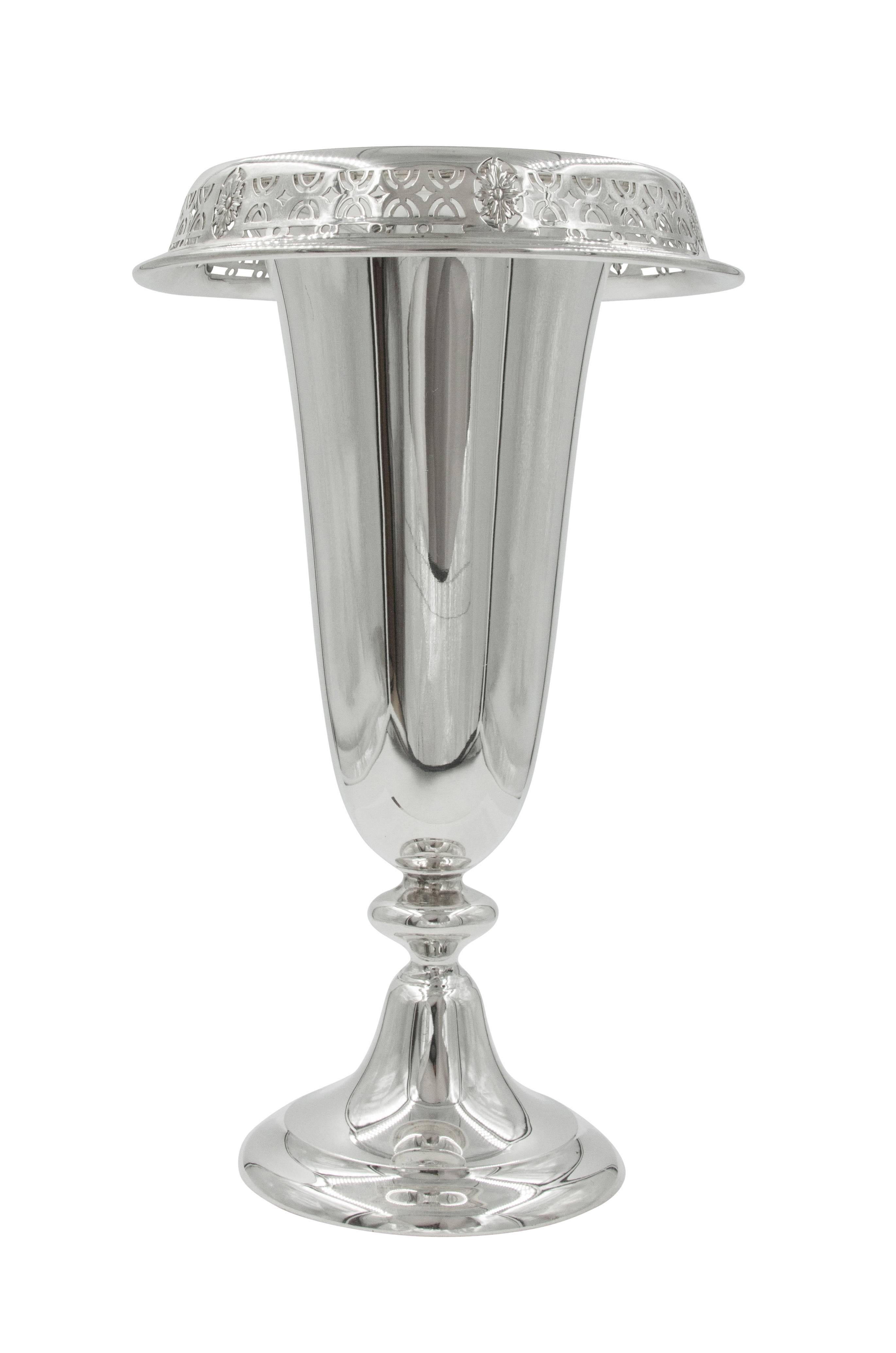 We are proud to offer this pair of vases that have an urn-like shape and a wide rim. The rim folds over and has a lovely symmetrical cutout design that adds a soft decorative feel to this otherwise simple piece. There are six leaf-like medallions