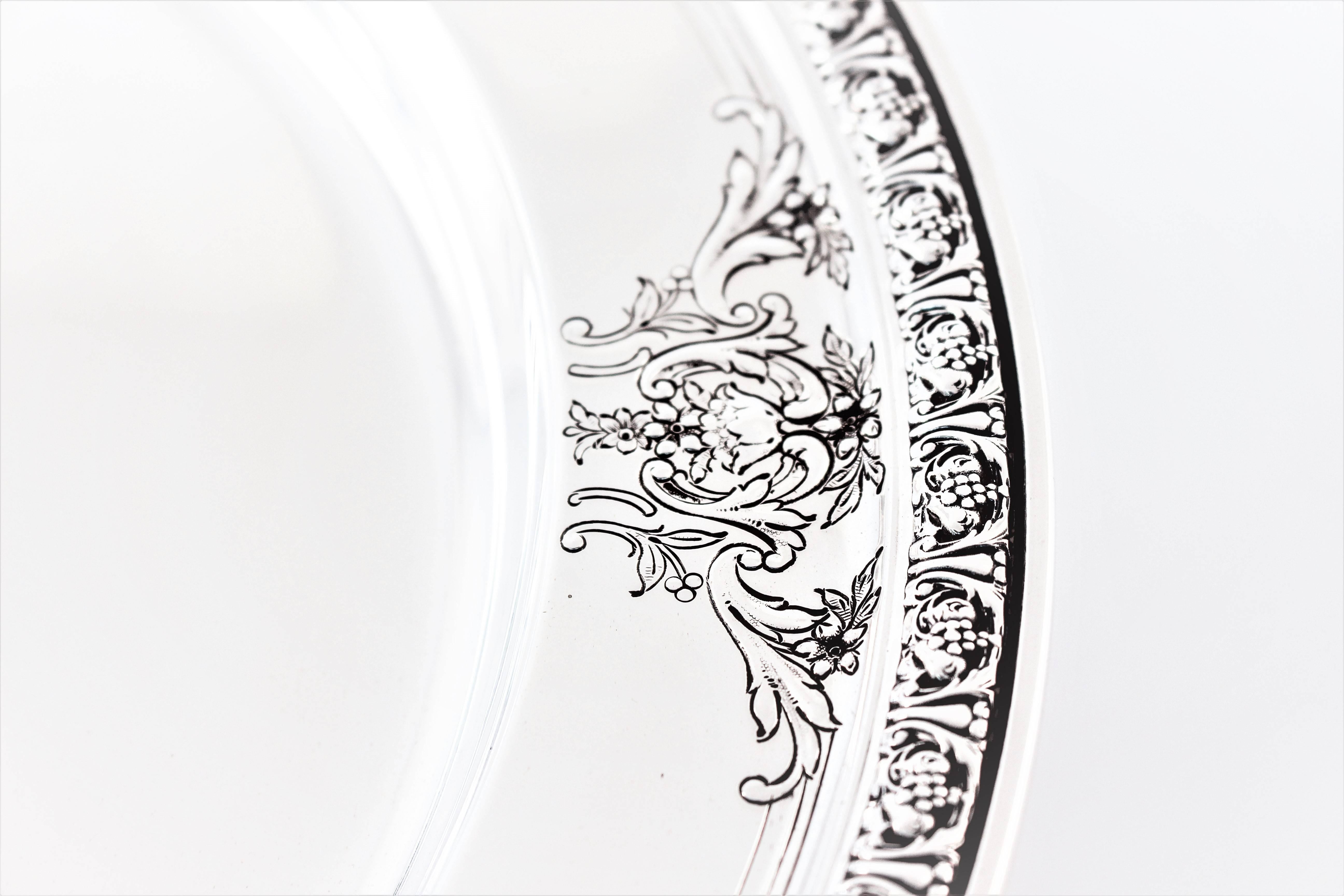 Around the edge is a detailed pattern, around the border are etched flowers, scrolls and leaves. The center dips in making this an ideal piece for serving food.
 