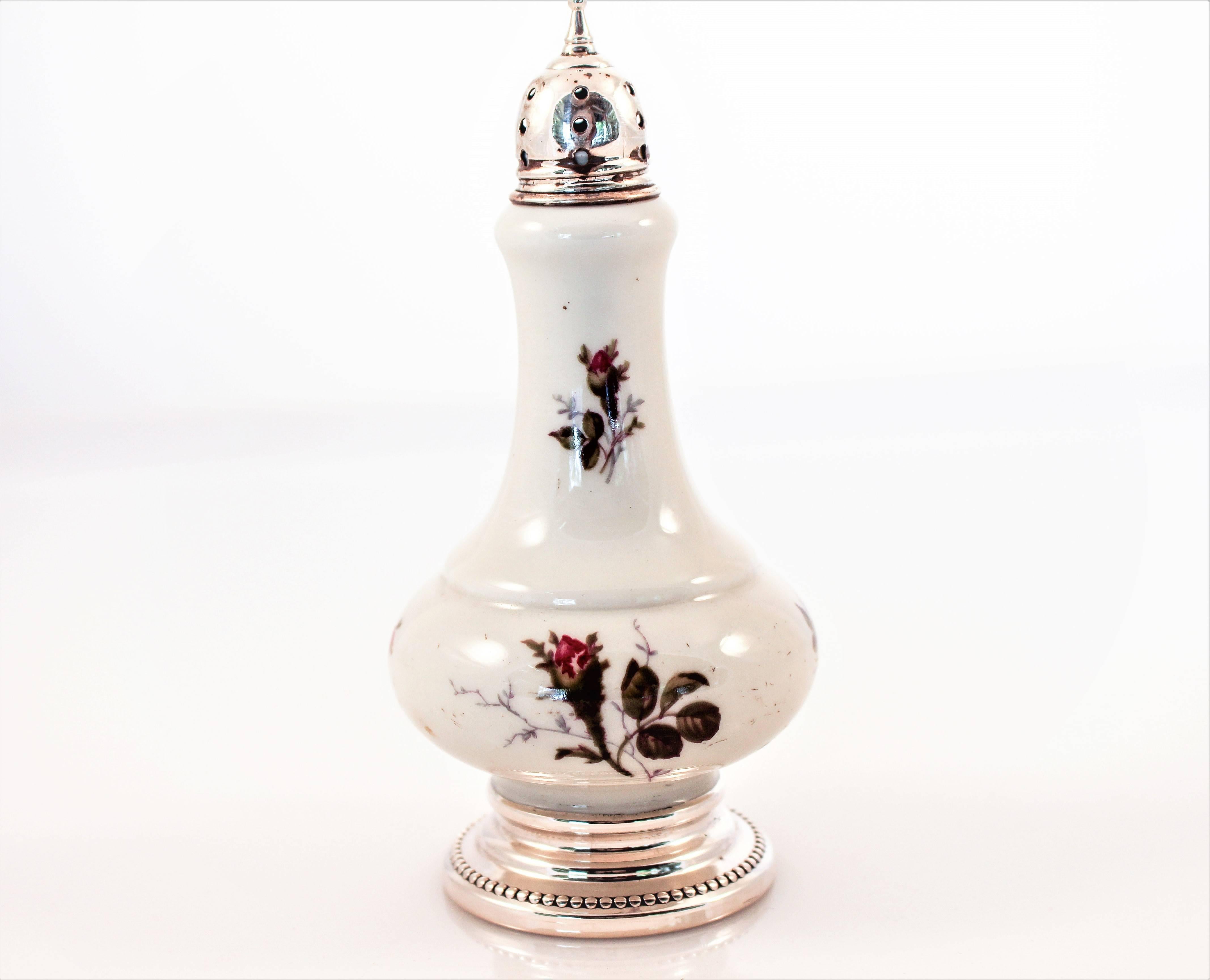 A moss-rose pattern decorates these delicate salt and pepper shakers, both around the belly and neck. Deep shades of green and red against the antique-white background really stand-out.
