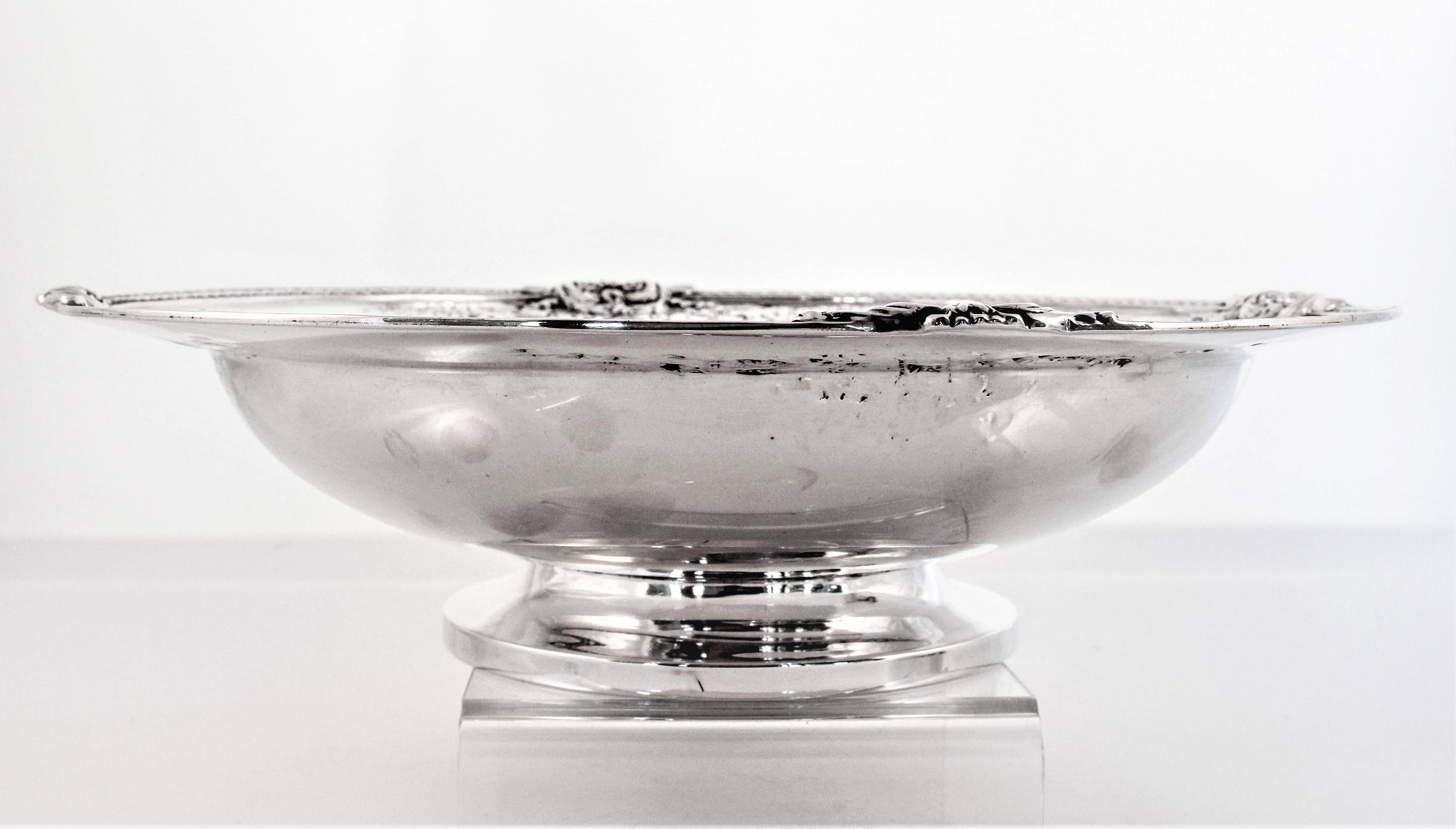 Standing proud on a centre pedestal, this bowl is just so pretty. A braid-like pattern encircles the rim. Pierced by four raised decorations on each side etched flowers and vines flow towards each other.