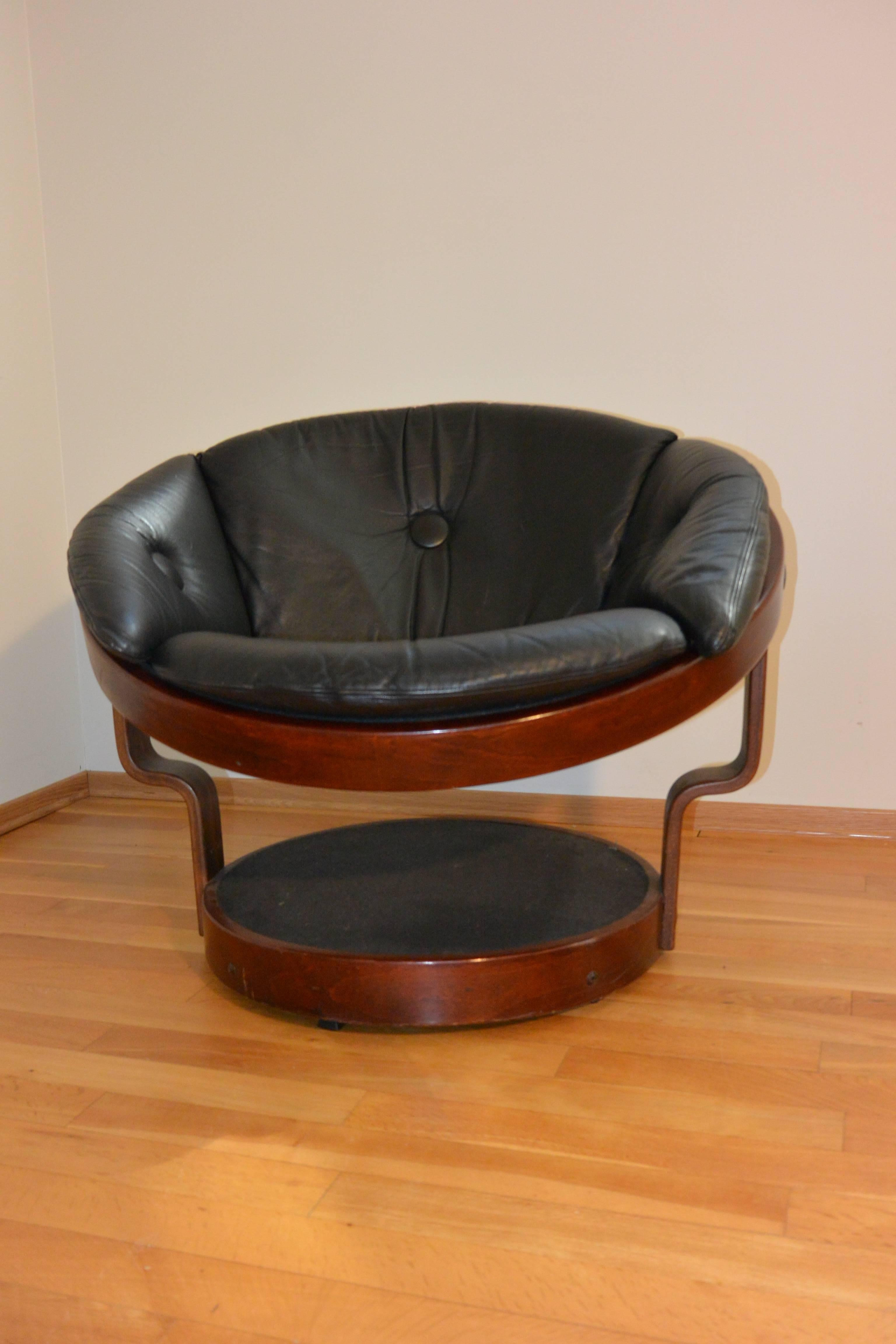 Black leather swivel chair by Oddmund Vadd, Norway.

The swivel chair is made from beech/laminated rosewood and bent into shape. The canvas is made from woven nylon to create a hammock effect to support the black leather cushion. The chair has a
