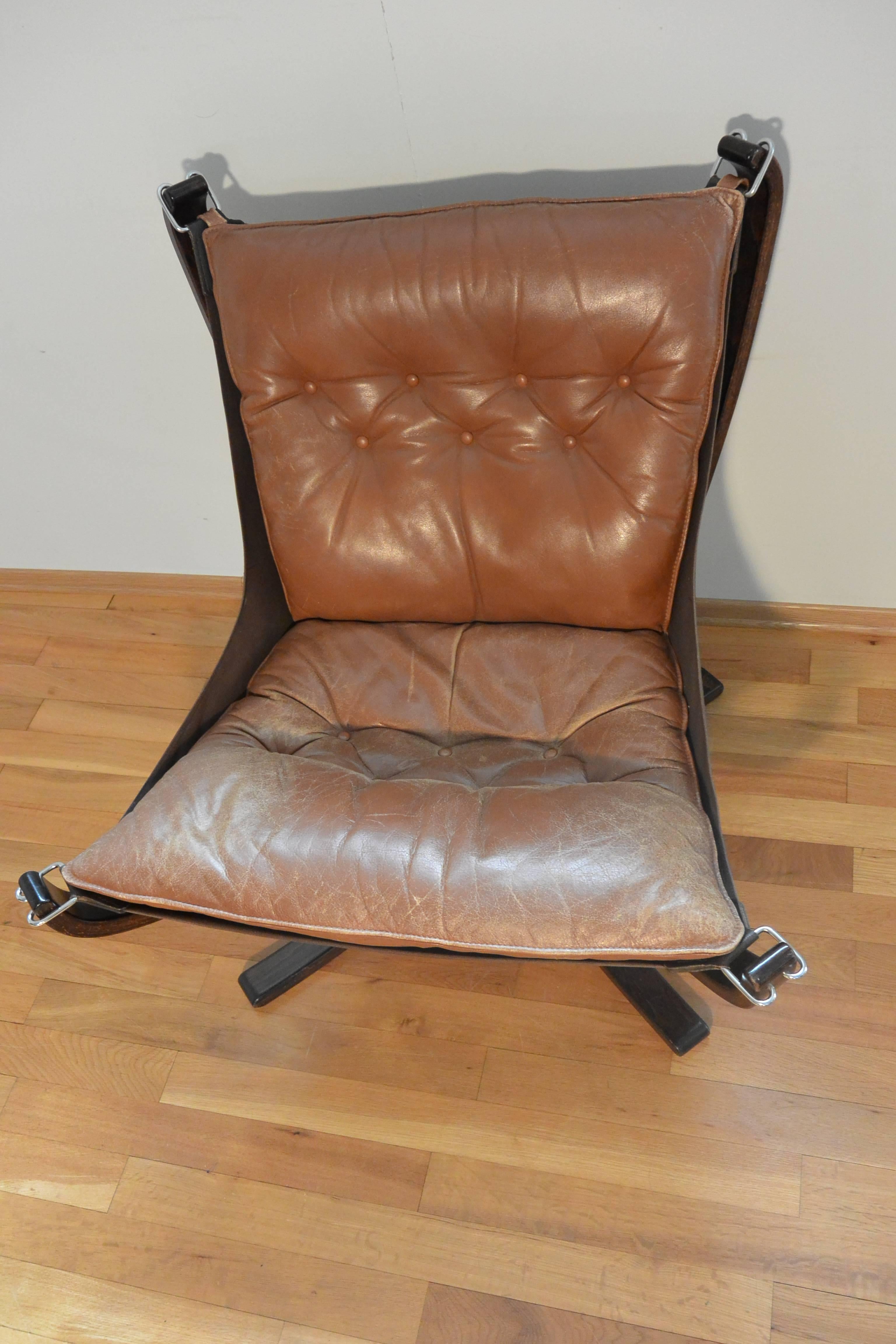 Falcon chair pair in mid-brown direct from Norway. Complimentary shipping included to UK. This pair of Falcon chairs have been well used and have a lovely patina.

 The frame is made from laminated rosewood and features stainless steel clips that
