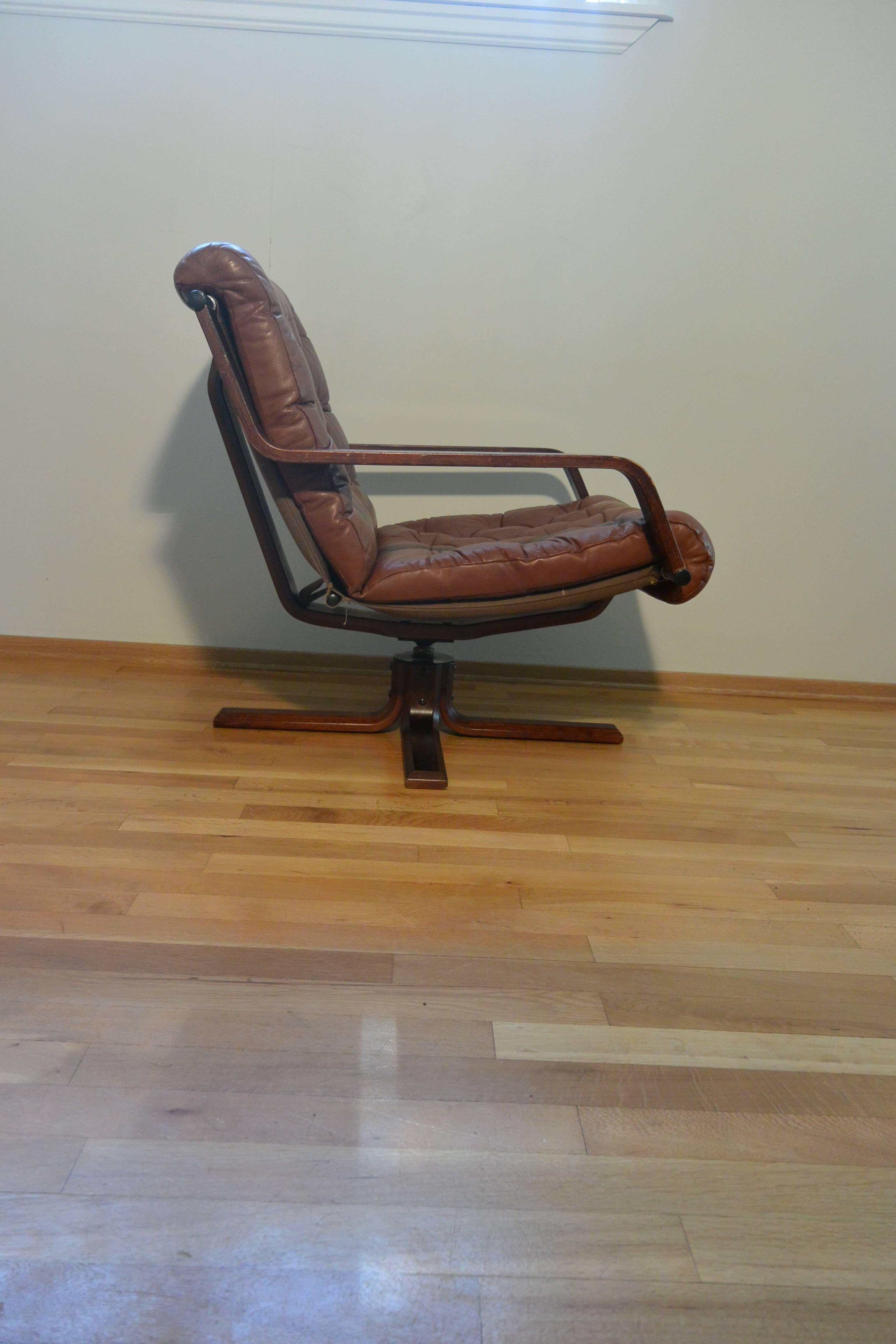 A rare woodman swivel chair in cognac leather, price includes matching footstool. Excellent condition 1975 designed by Sigurd Ressell the designer of the Falcon chair, manufactured by Vatne Møbler, Norway. 

A rare gem confirmed from the Vatne