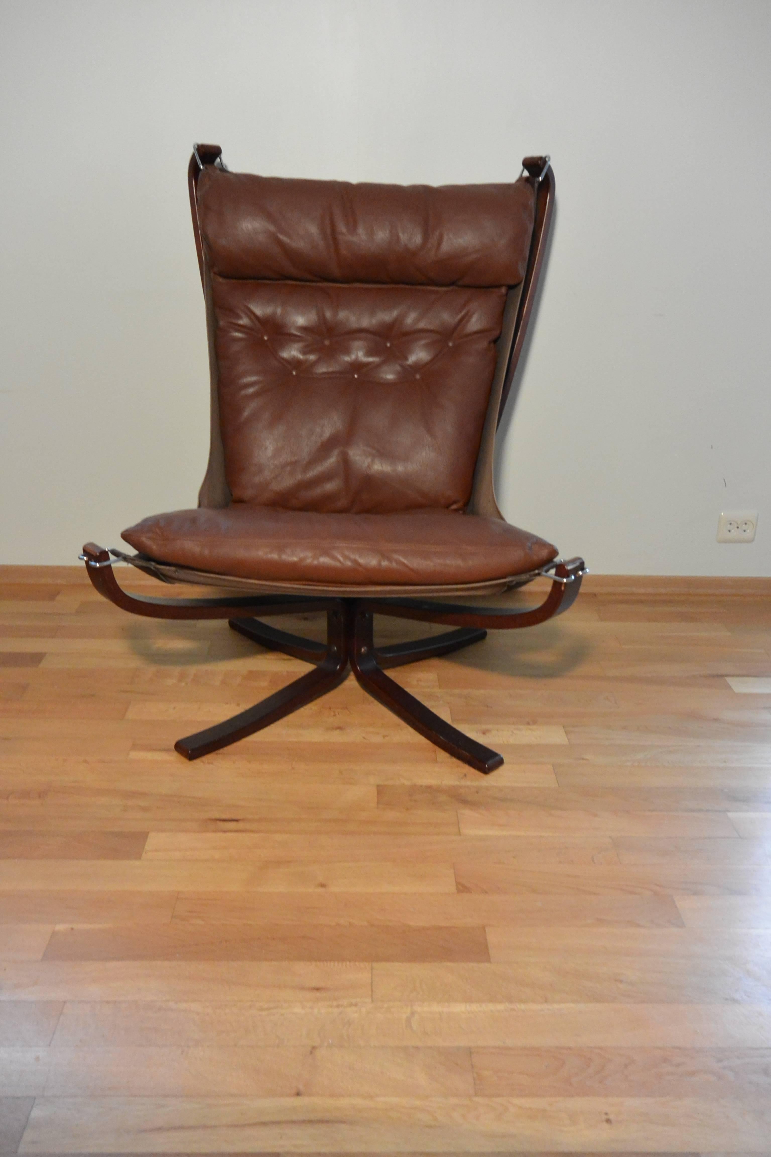 Chestnut brown high back Falcon chair. 

Based in Norway sourcing original vintage Falcon chairs. The frame is constructed from laminated bentwood / laminated rosewood and is bolted to a steel rectangular tube creating a study base. Easily