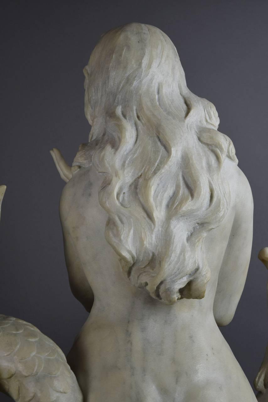 The mermaid, with flowing tresses and open arms, is entwined with the dolphin in the tumbling waves.