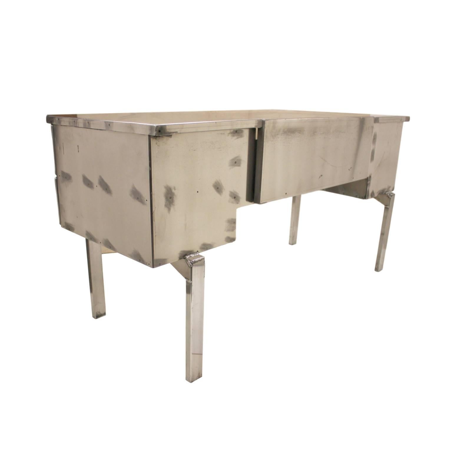 This desk was originally a medical field desk for the US military. Desk is completely constructed from aircraft-grade aluminium and features a very novel folding design that allowed it to be easily transported. We hand-stripped the outside of the