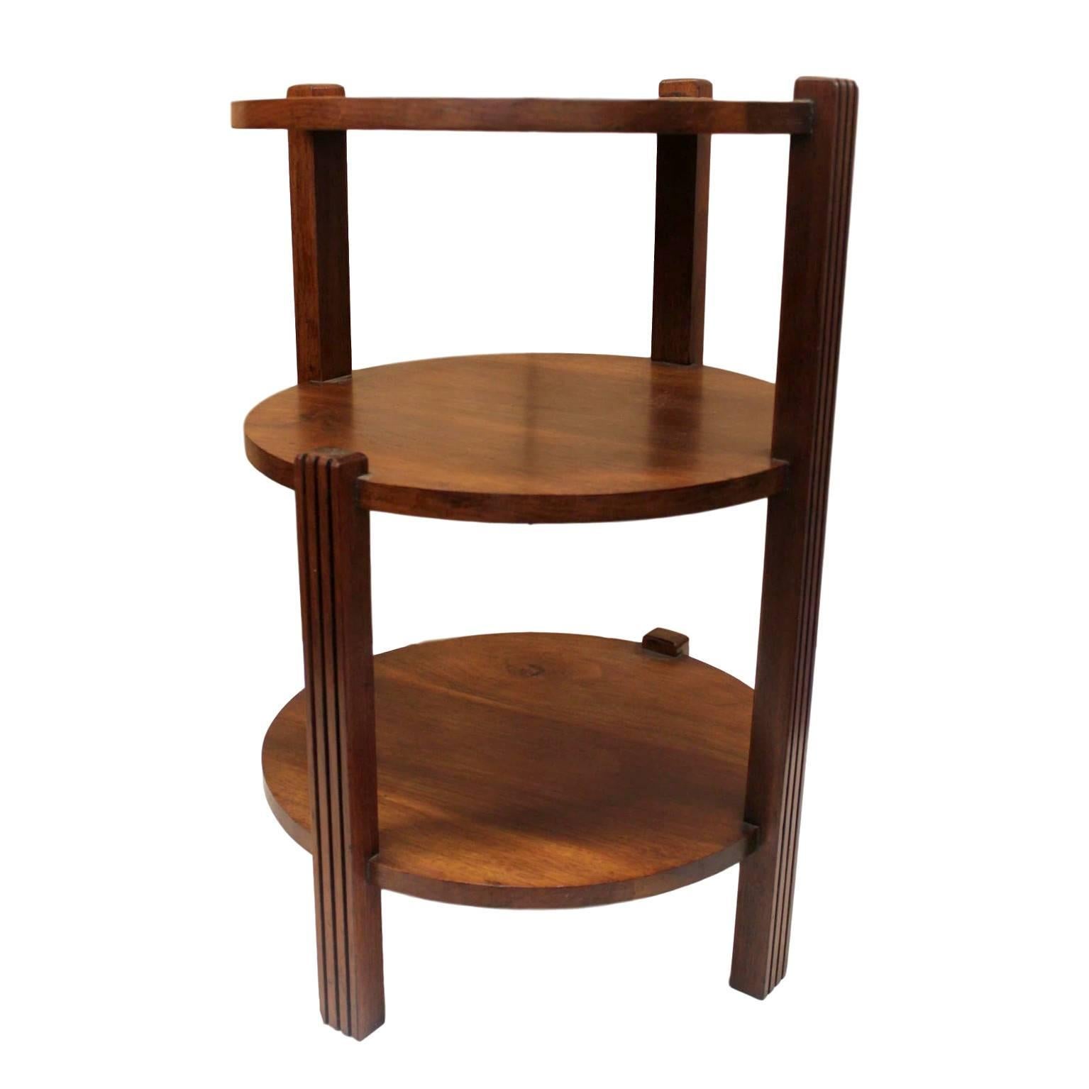 This wonderful little occasional table features three tiers of round walnut shelves supported by five legs/supports. These supports are arranged in a unique staggered fashion that gives the table's profile an interesting 