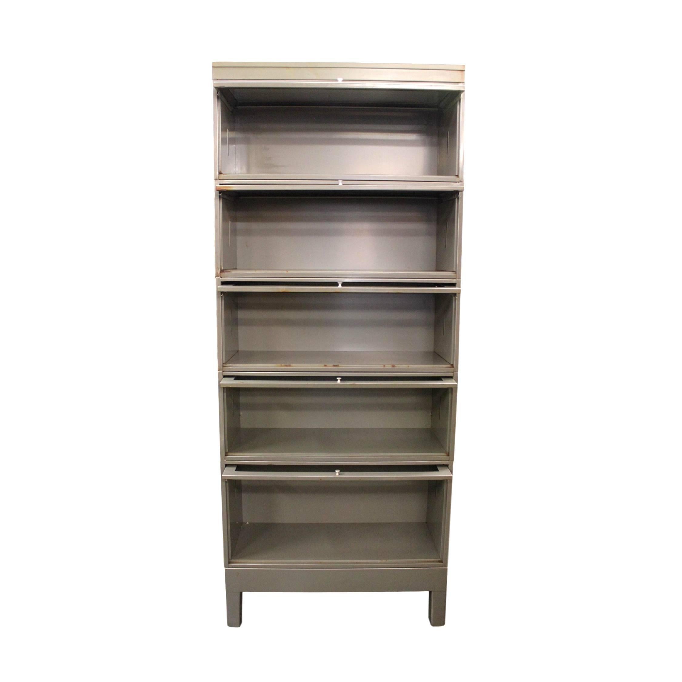 Fantastic vintage metal barrister bookcase.  Bookcase stands over 6 1/2 feet tall and features a great industrial patina to its original gray paint, steel construction,  aluminum hardware, and clear, crack-free glass.  Would add some impressive
