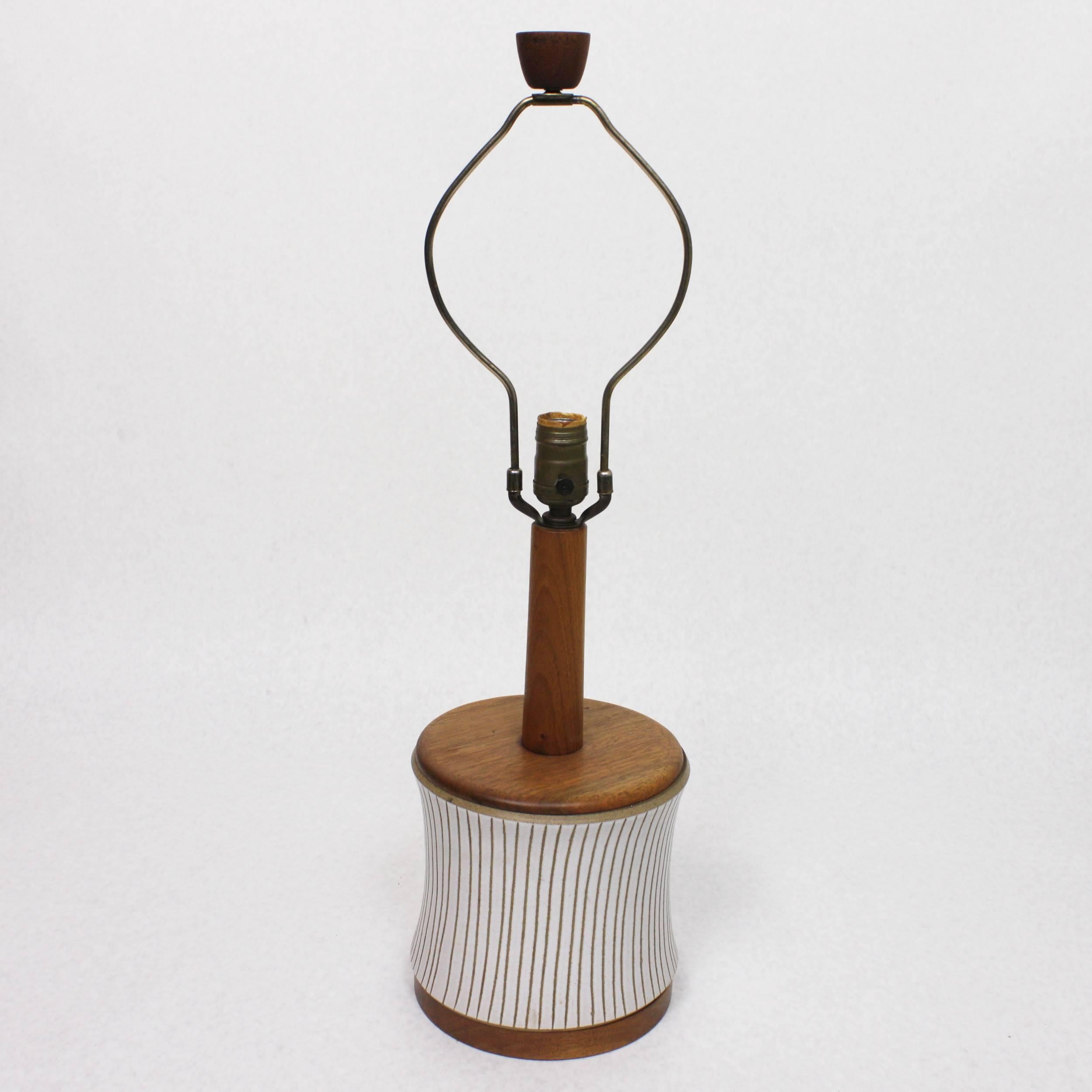 This wonderful model 218-28-D9 table lamp was designed by Gordon & Jane Martz and manufactured at their Marshall Studios facility in Veedersburg, IN. Lamp features an incised white and tan ceramic body with turned walnut, base, top, neck and finial.